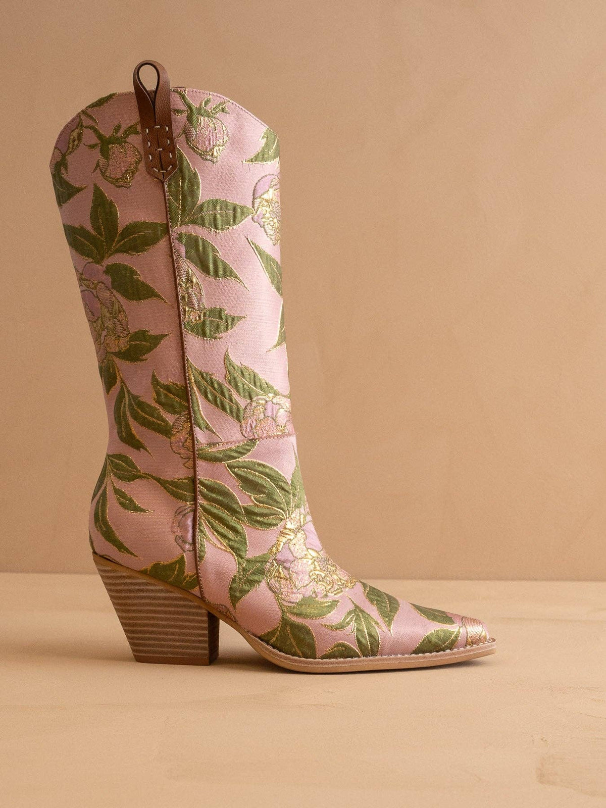 Pink floral patterned boots on a beige background
