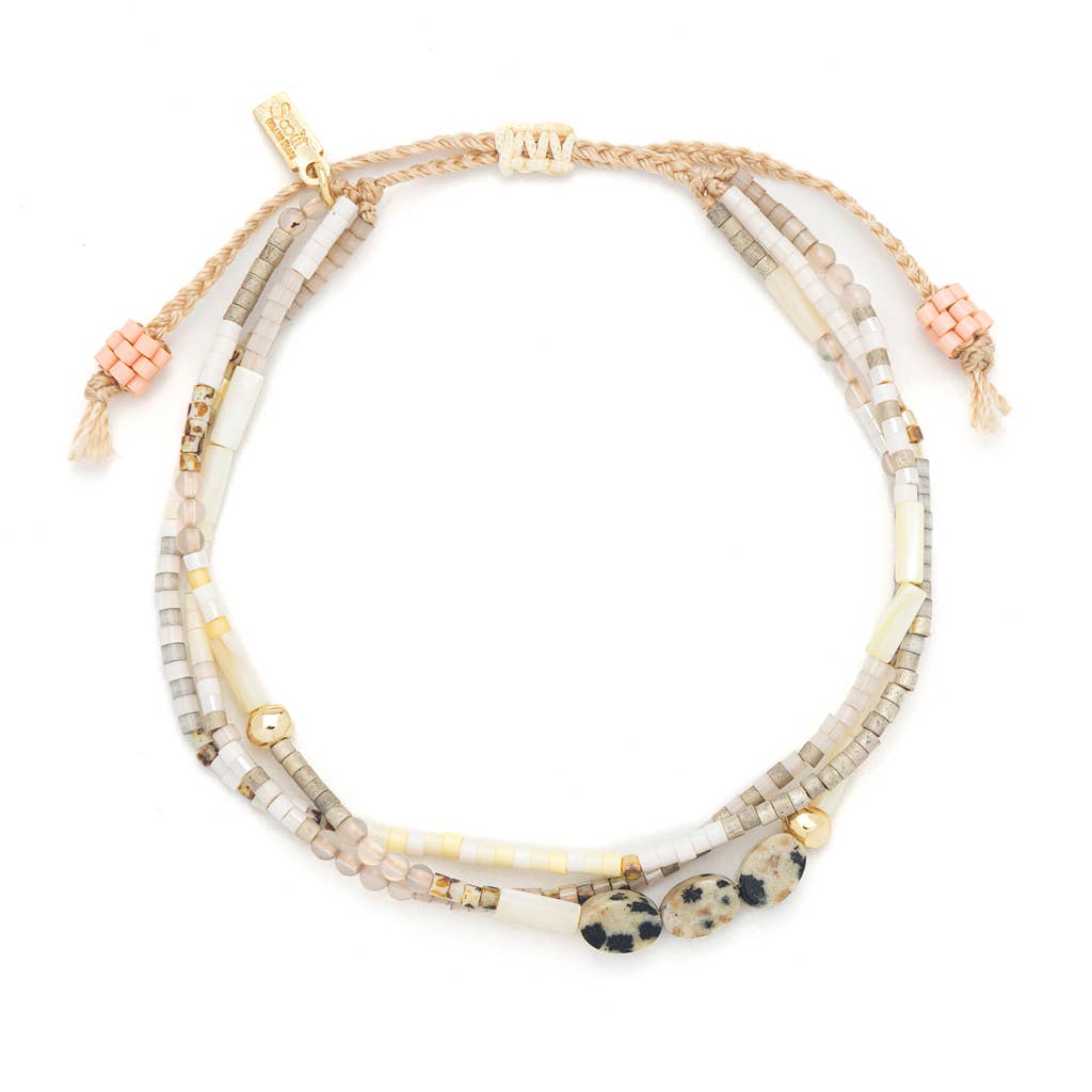 Multistrand beaded bracelet with gold accents on a white background