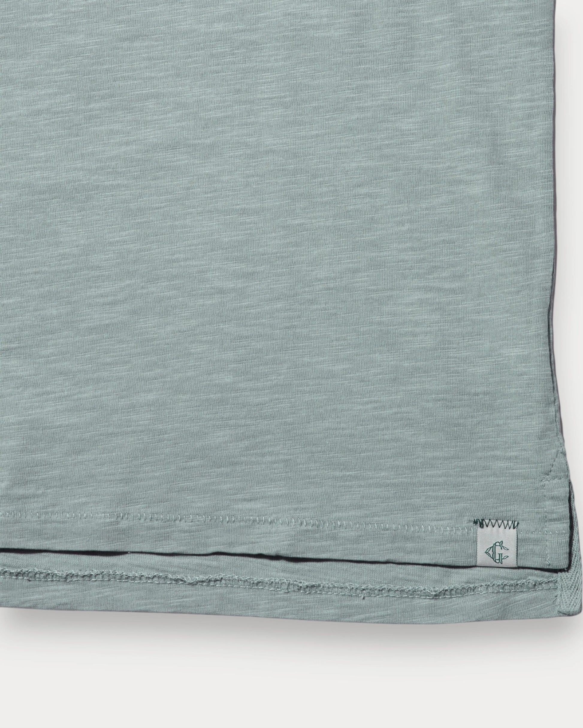 Close-up of a light blue fabric with a brand label on a white background