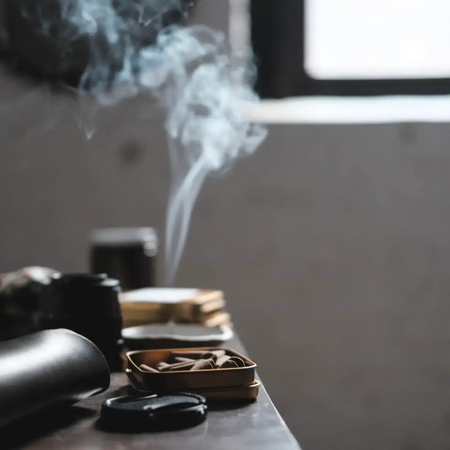 Smoking activity with smoke rising from a pipe on a wooden surface.