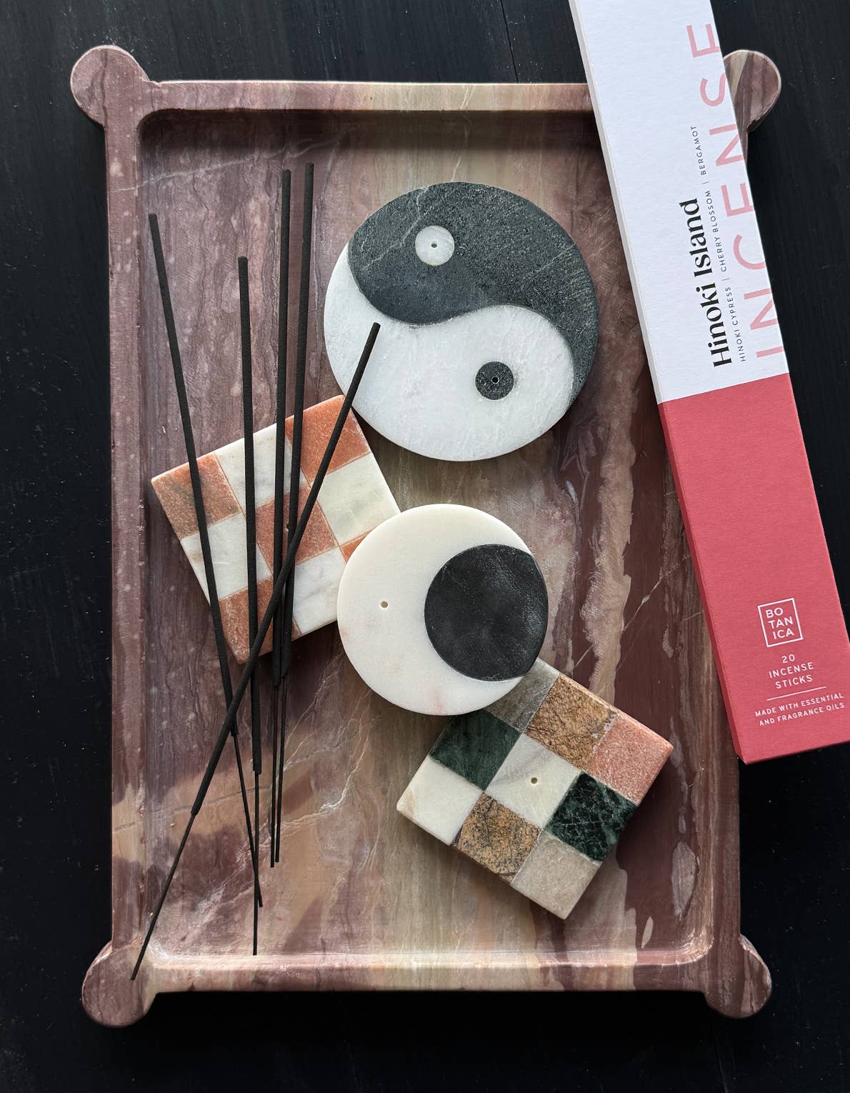 Decorative items including stones with checkered patterns and incense sticks on a wooden tray, with a box labeled 'Hokkaido Island' in the background.