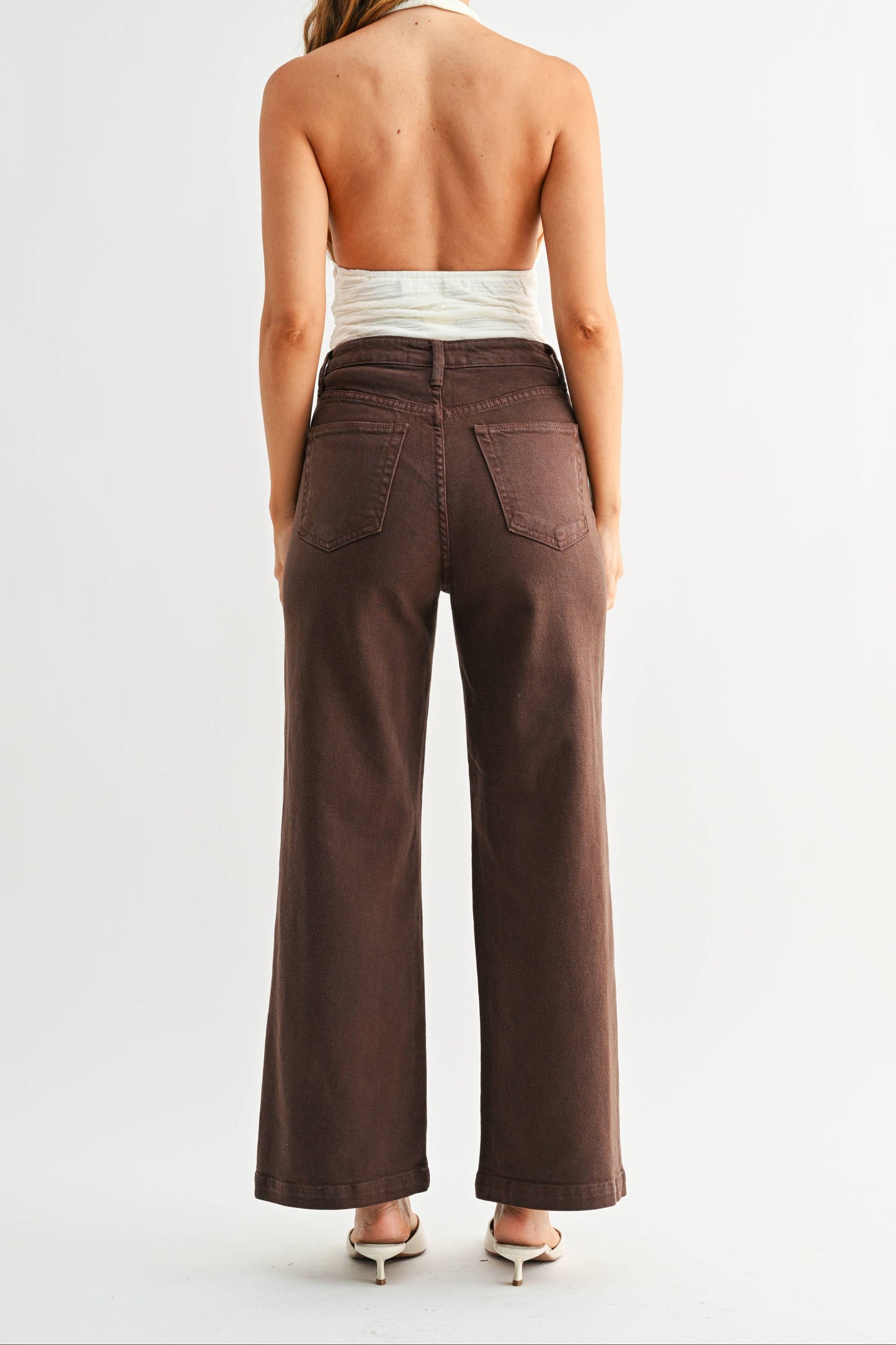 Woman wearing brown wide-leg pants on a white background