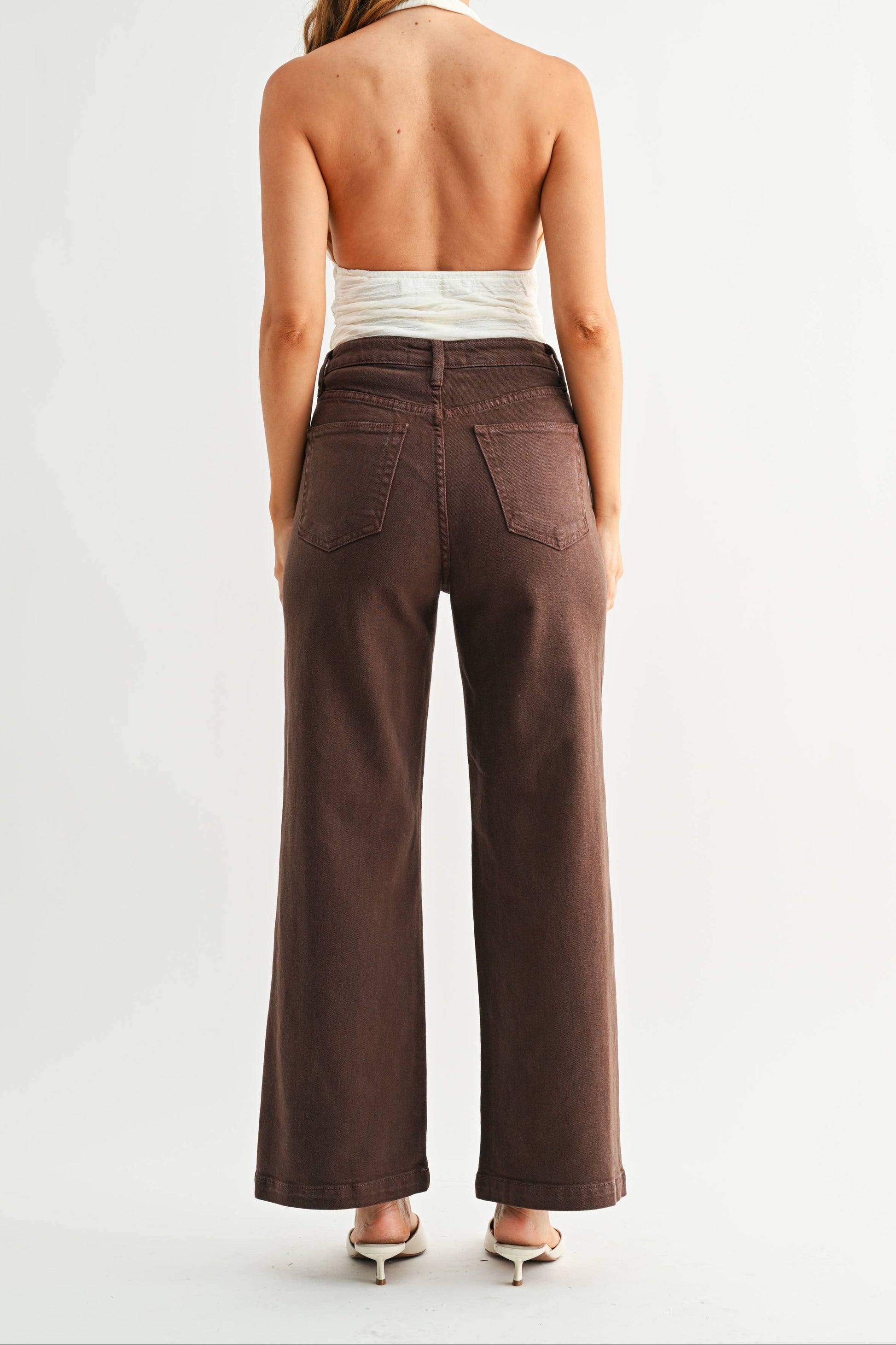 Woman wearing brown wide-leg pants on a white background