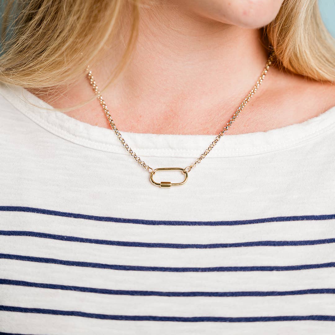 Gold necklace worn by a person with a white and blue striped shirt
