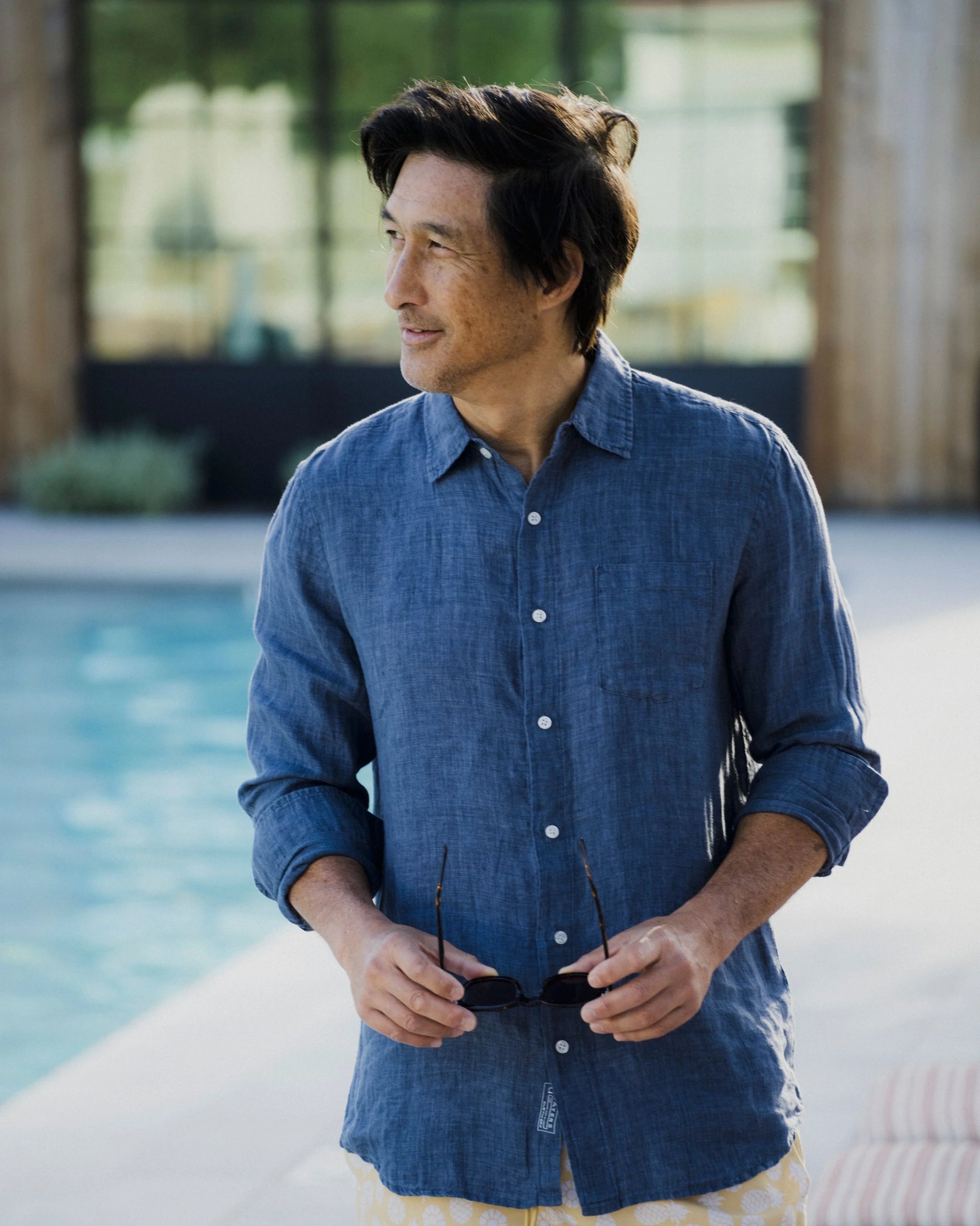 Man wearing a blue shirt by a pool