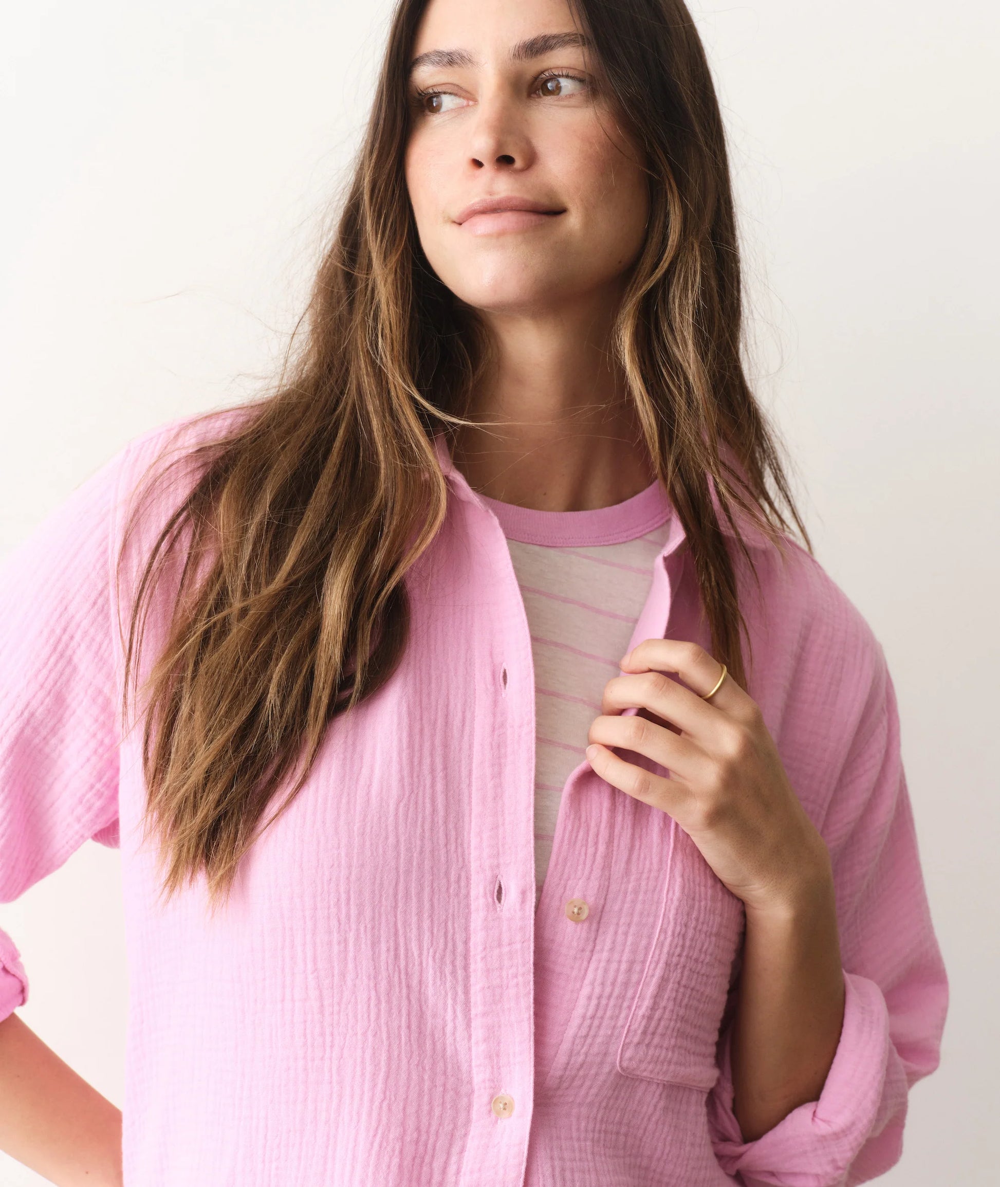 Woman wearing a pink textured shirt against a white background
