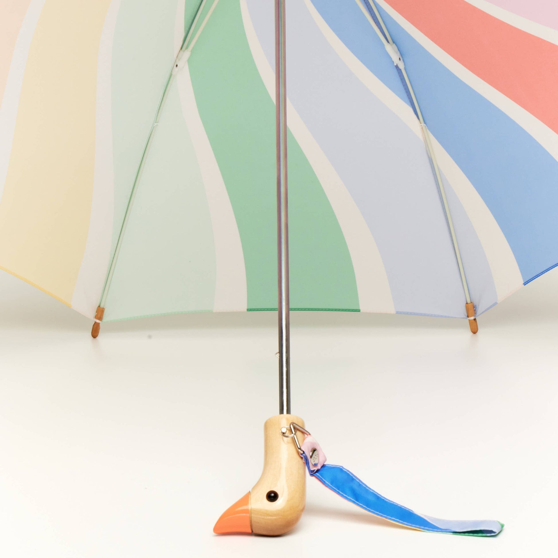Colorful umbrella with a bird-shaped keychain on a white background
