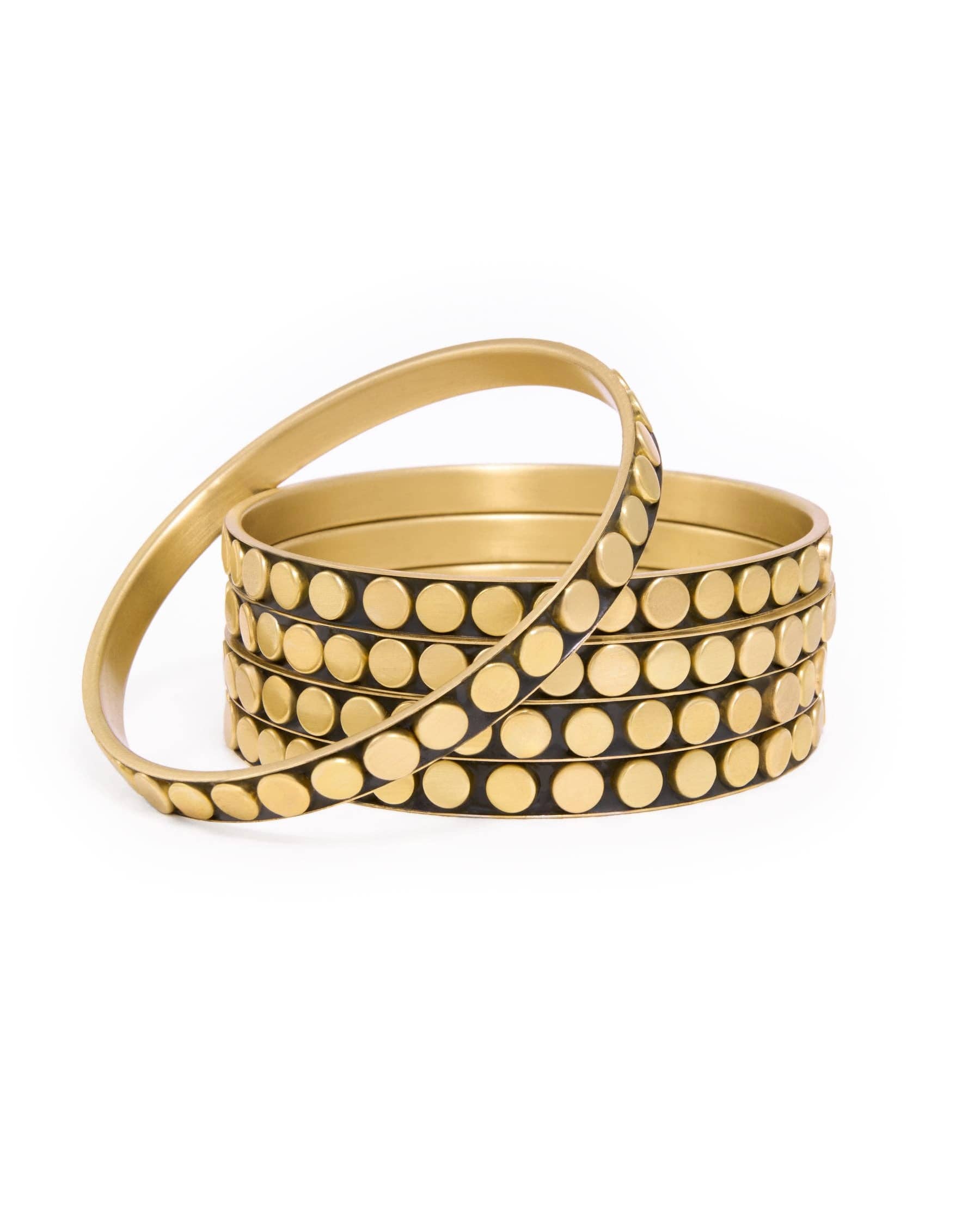 A stack of gold-toned bangles with rows of small round studs, photographed on a clean white background.