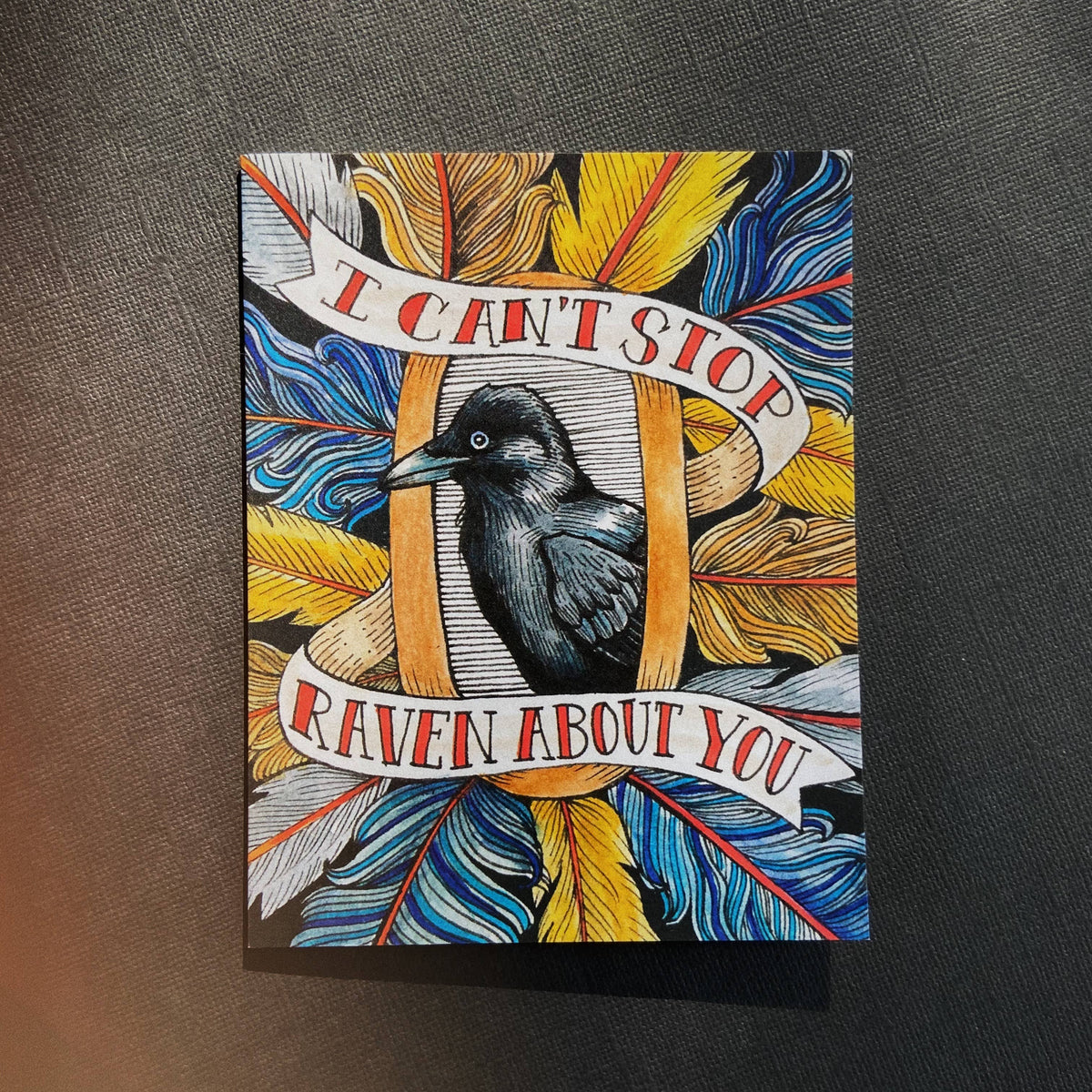 Card with a raven illustration and text on a textured surface