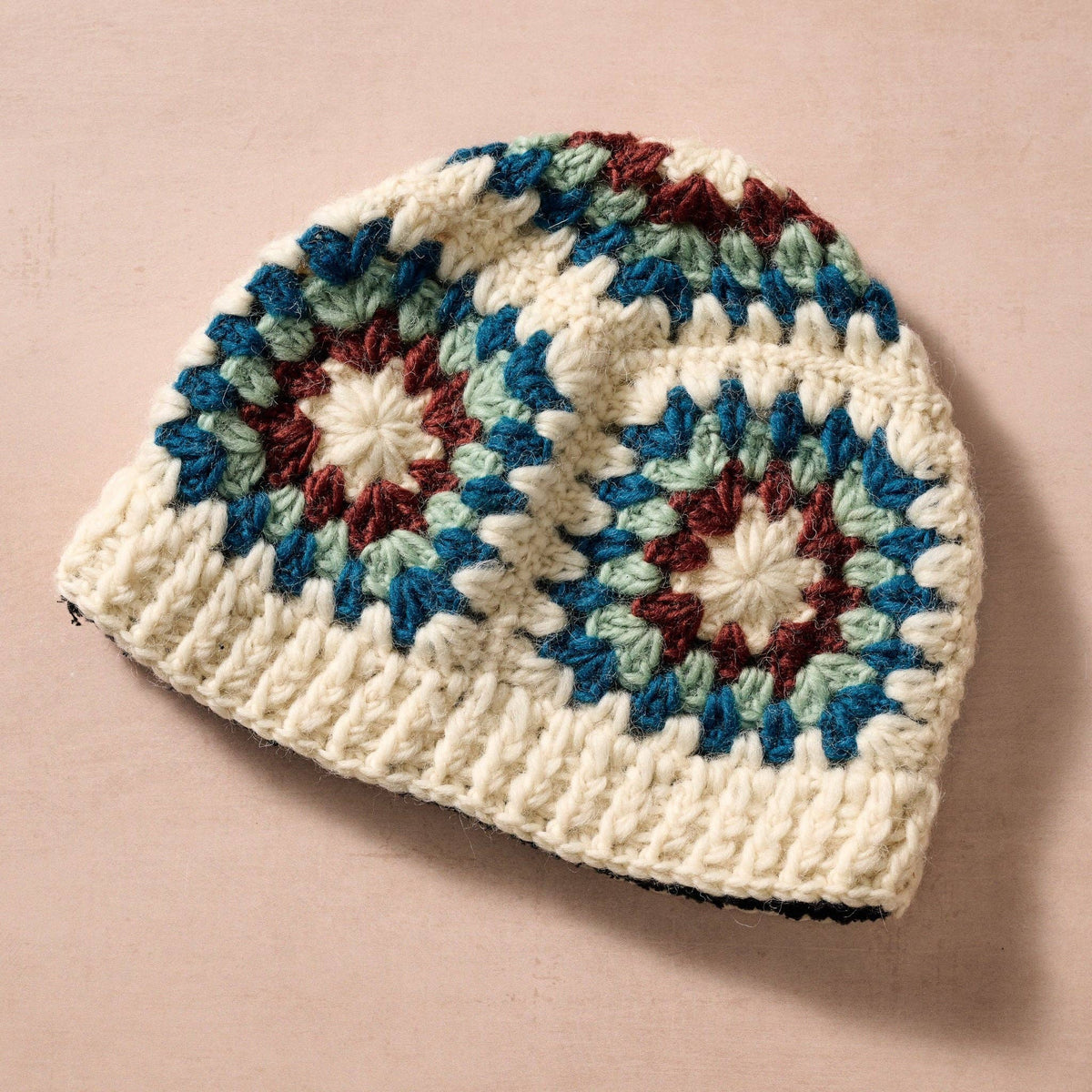Crocheted beanie with a multicolor pattern on a beige background
