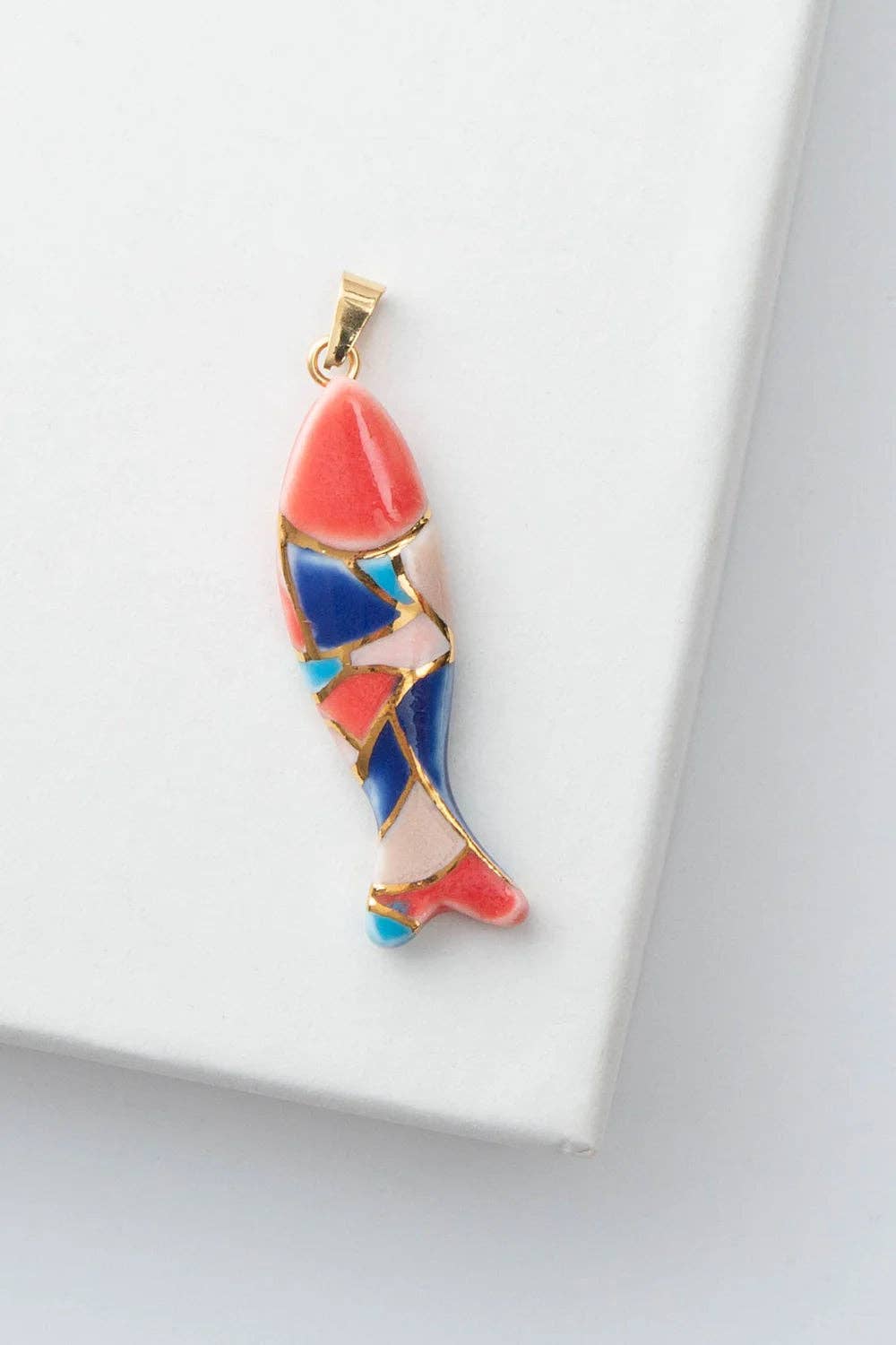 Colorful fish-shaped pendant on a white background