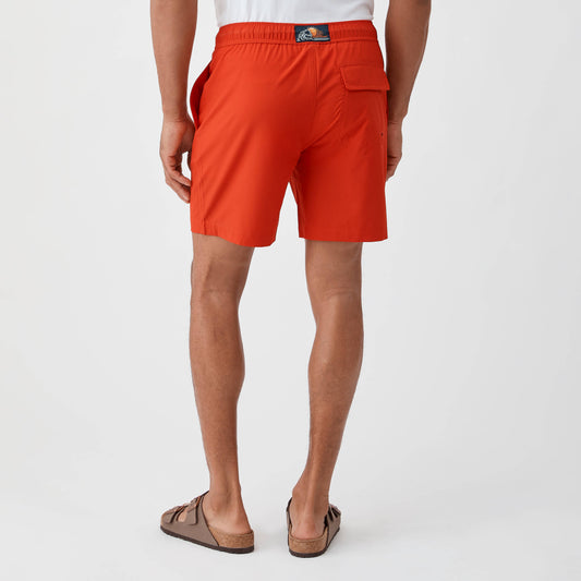 Person wearing bright orange shorts on a white background
