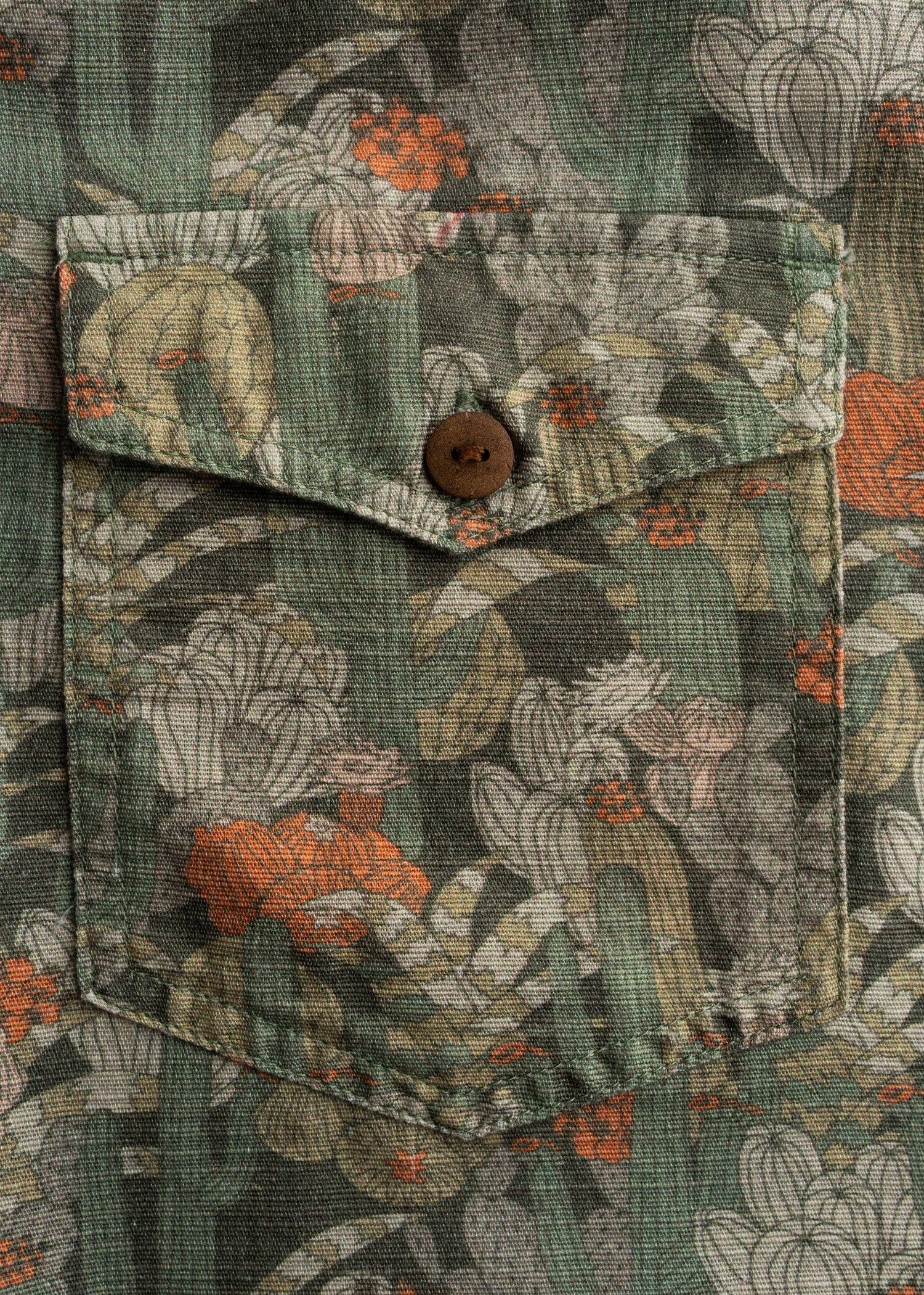 Close-up of a floral patterned shirt with a button and pocket.