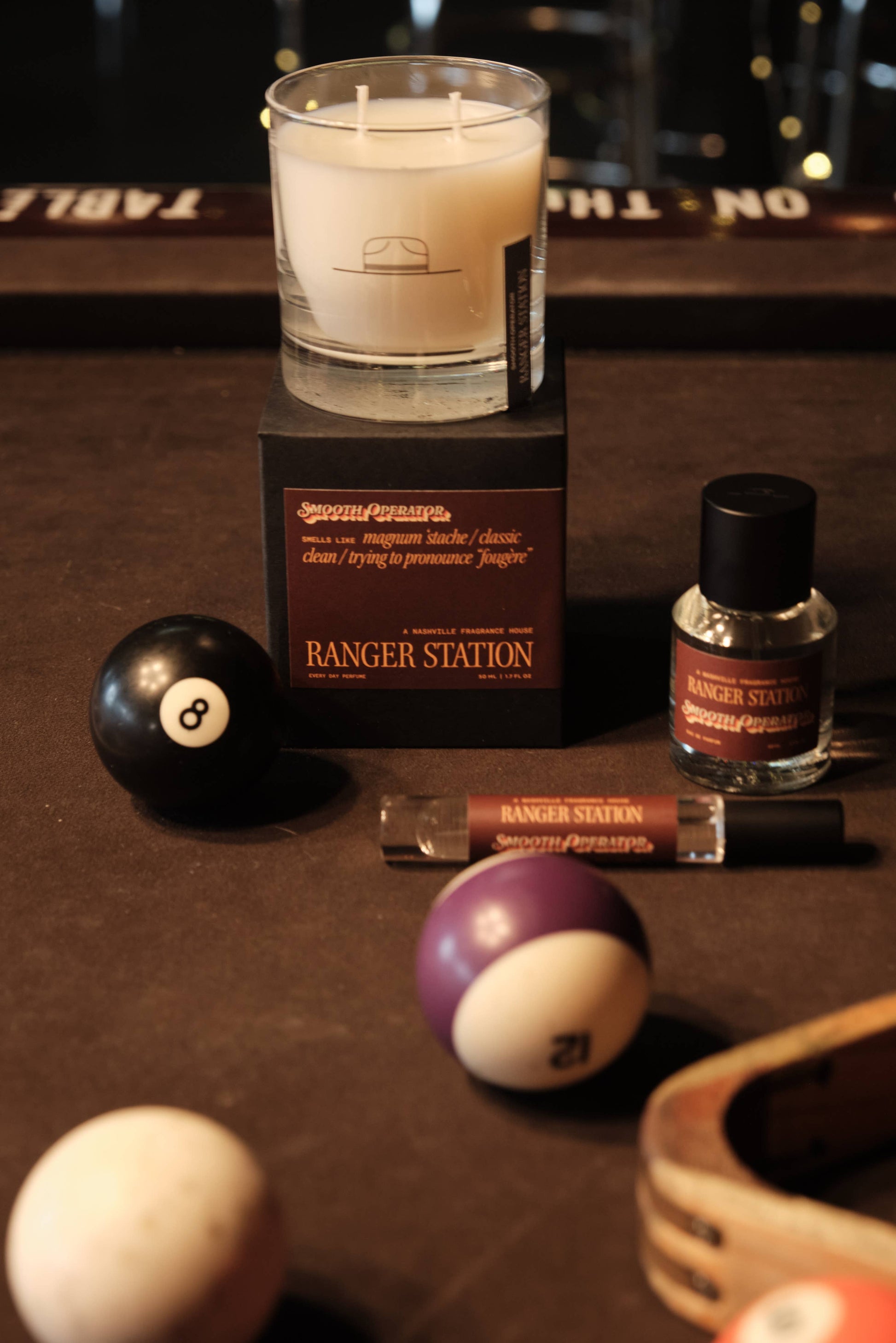 Candle, bottle, and pool balls on a table with 'Ranger Station' branding.