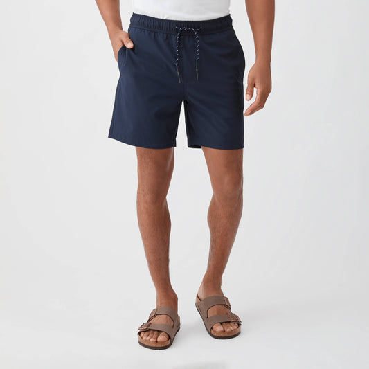 Person wearing navy shorts on a white background