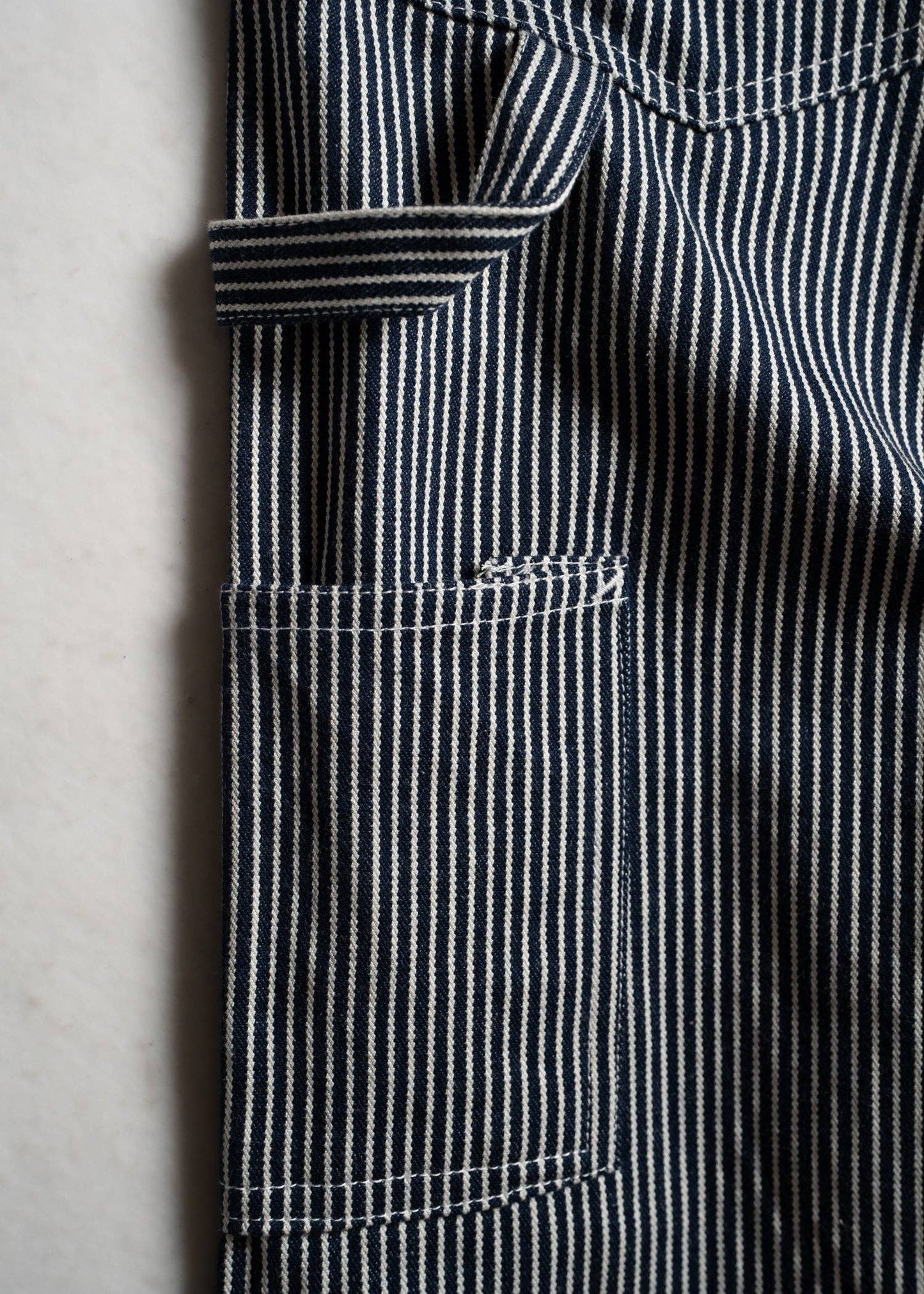 Close-up of a black and white striped fabric with a pocket on a light gray background
