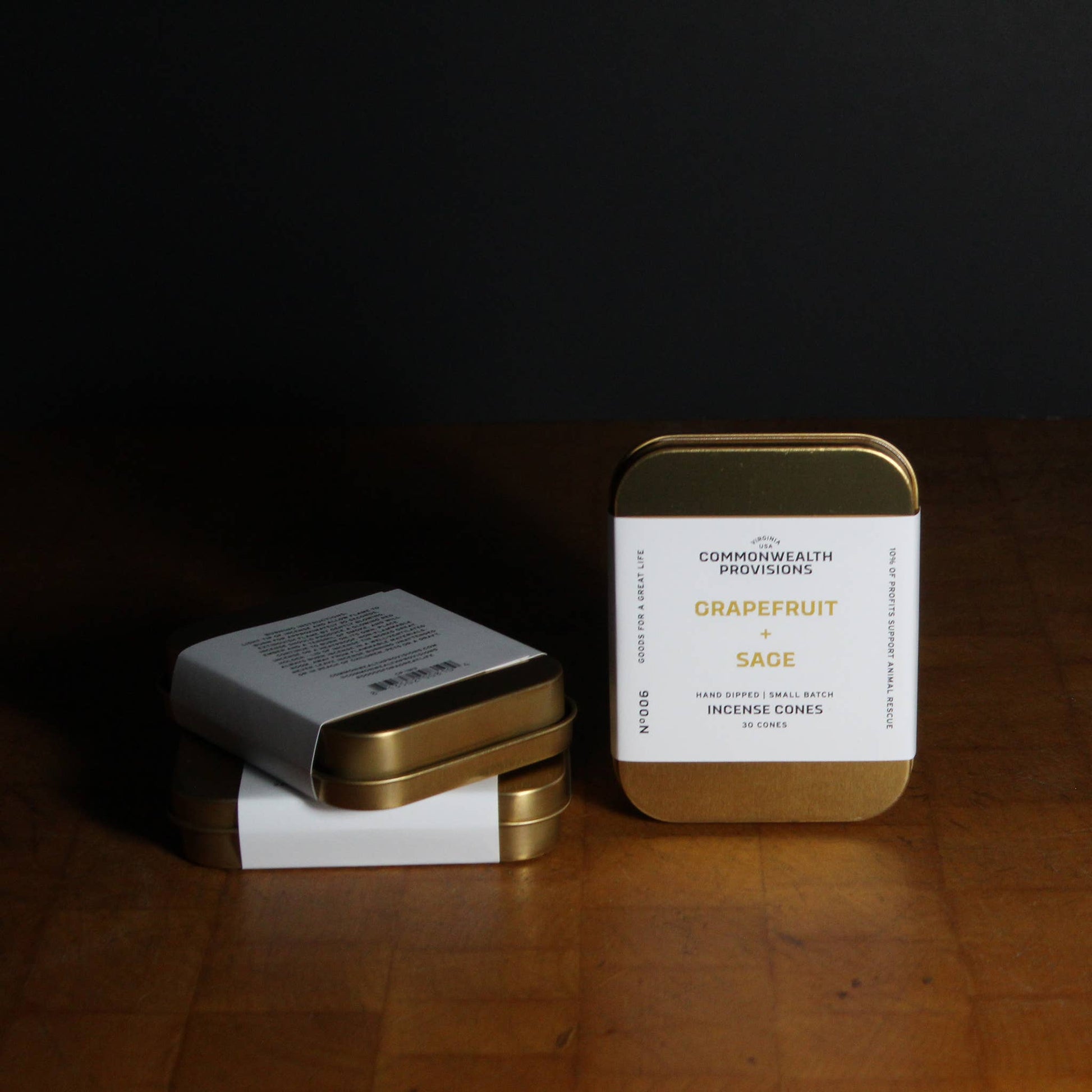 Three small metal tins with labels on a wooden surface
