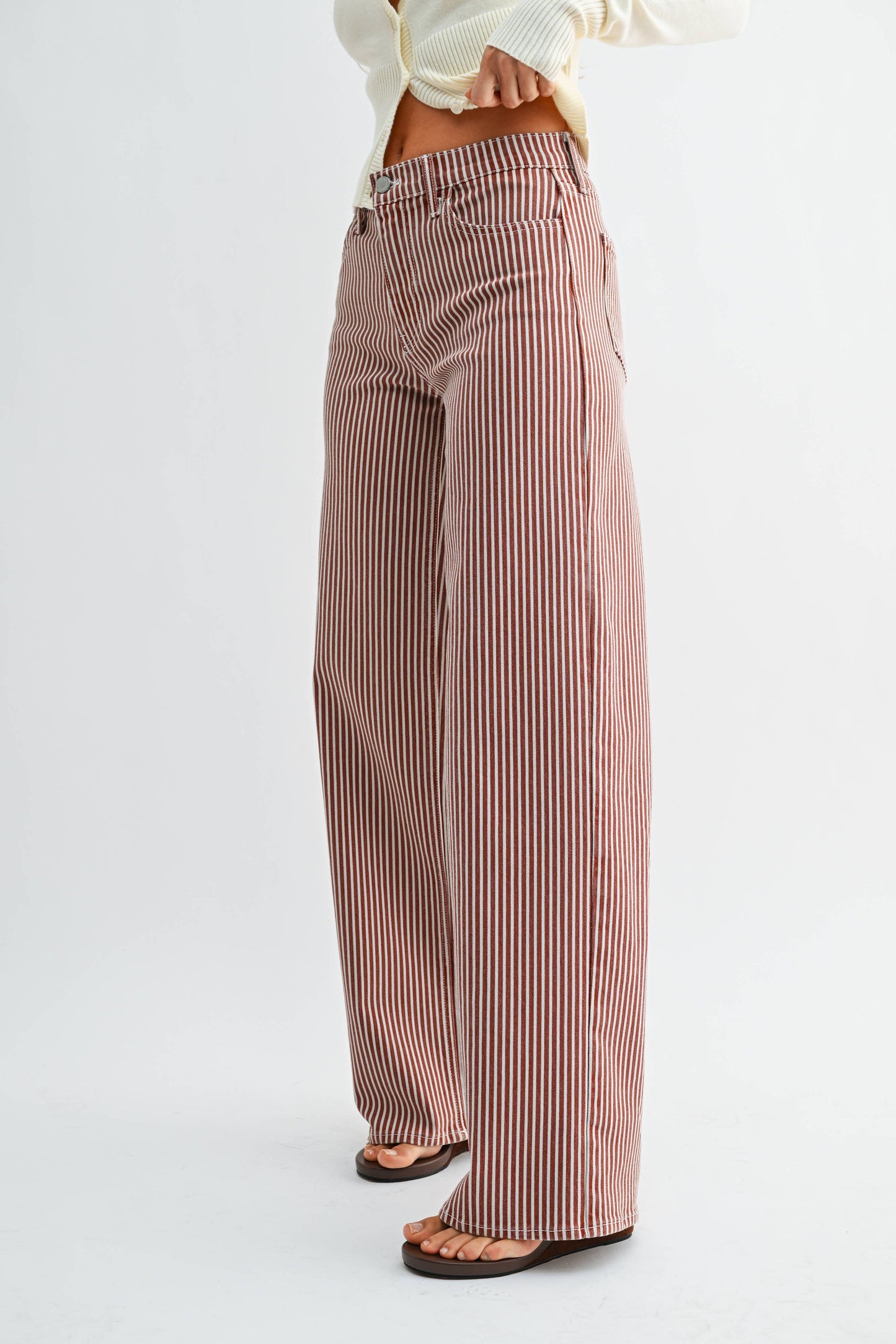 Striped pants worn by a person on a white background
