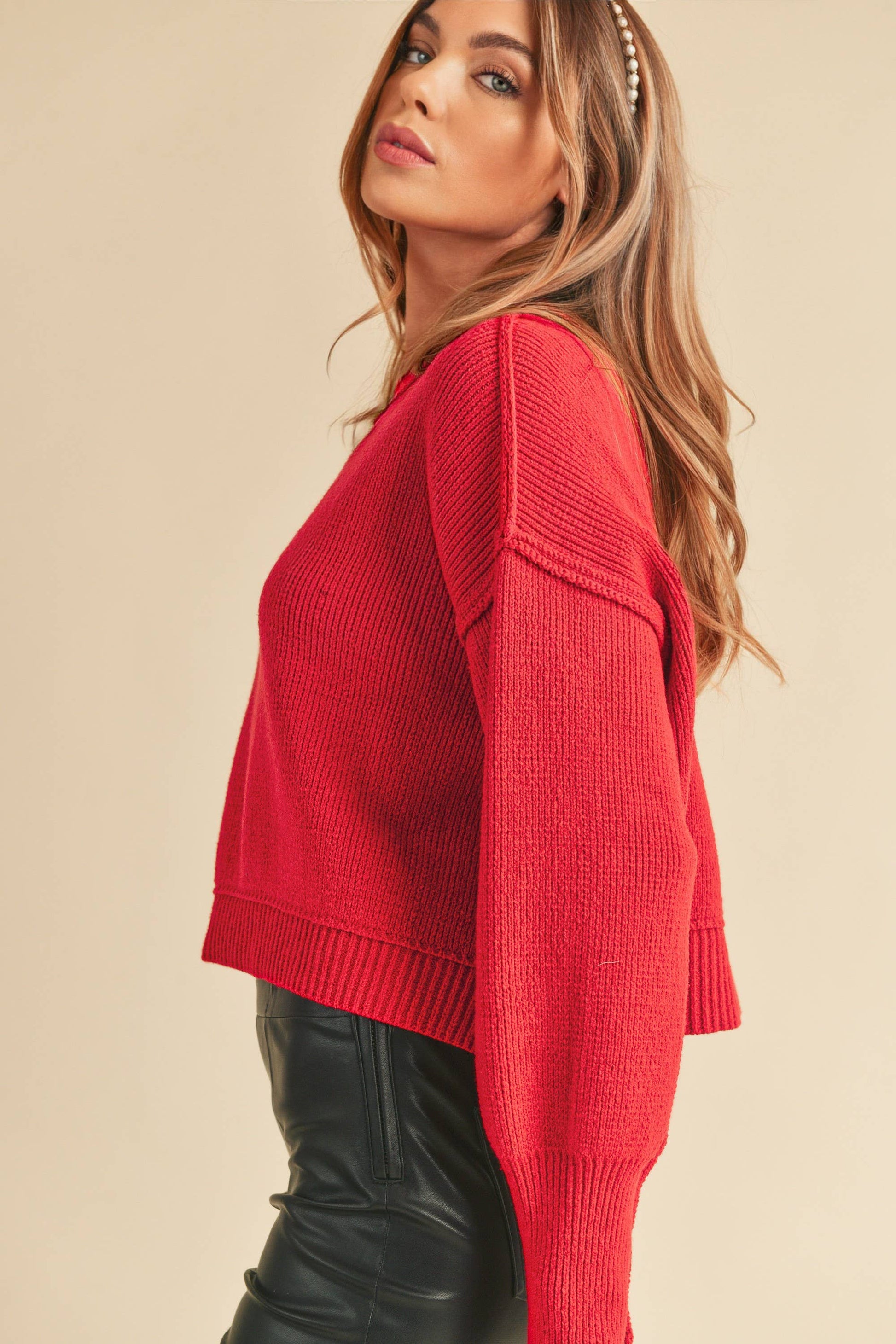 Woman wearing a red sweater against a beige background