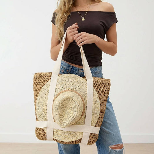 Woman holding a straw bag with a hat inside against a plain background