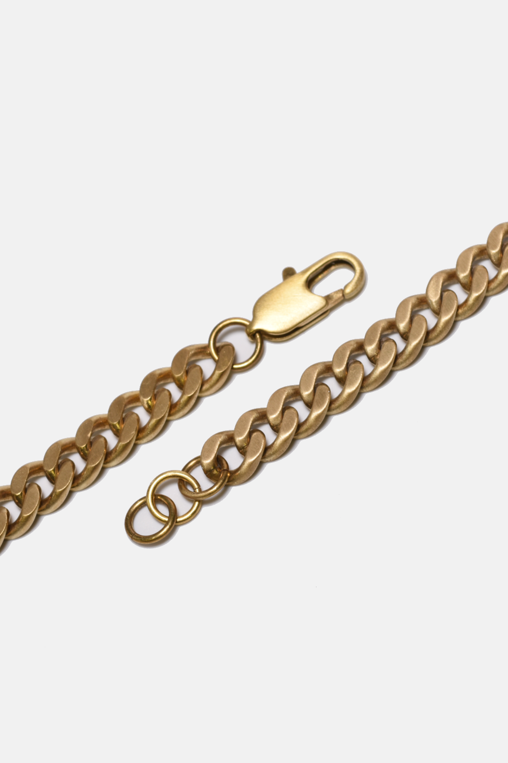 Gold chain bracelet on a light gray background