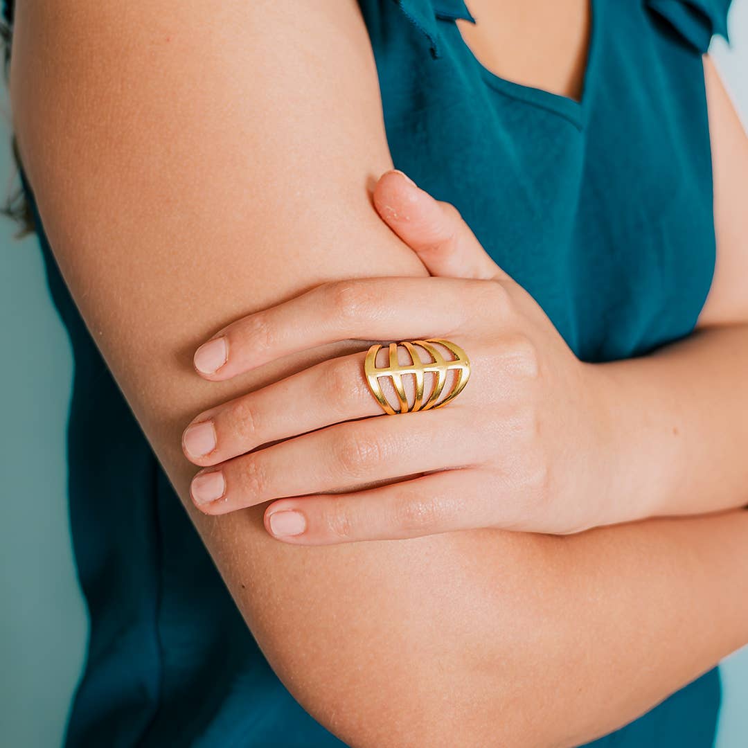 Gold ring on a person's finger with a blurred background