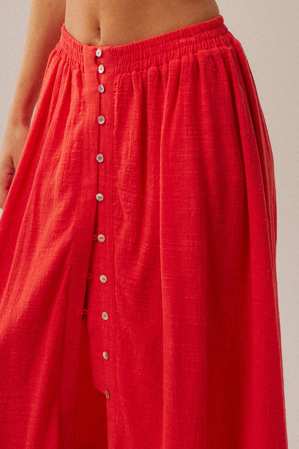 Red skirt with button details on a neutral background