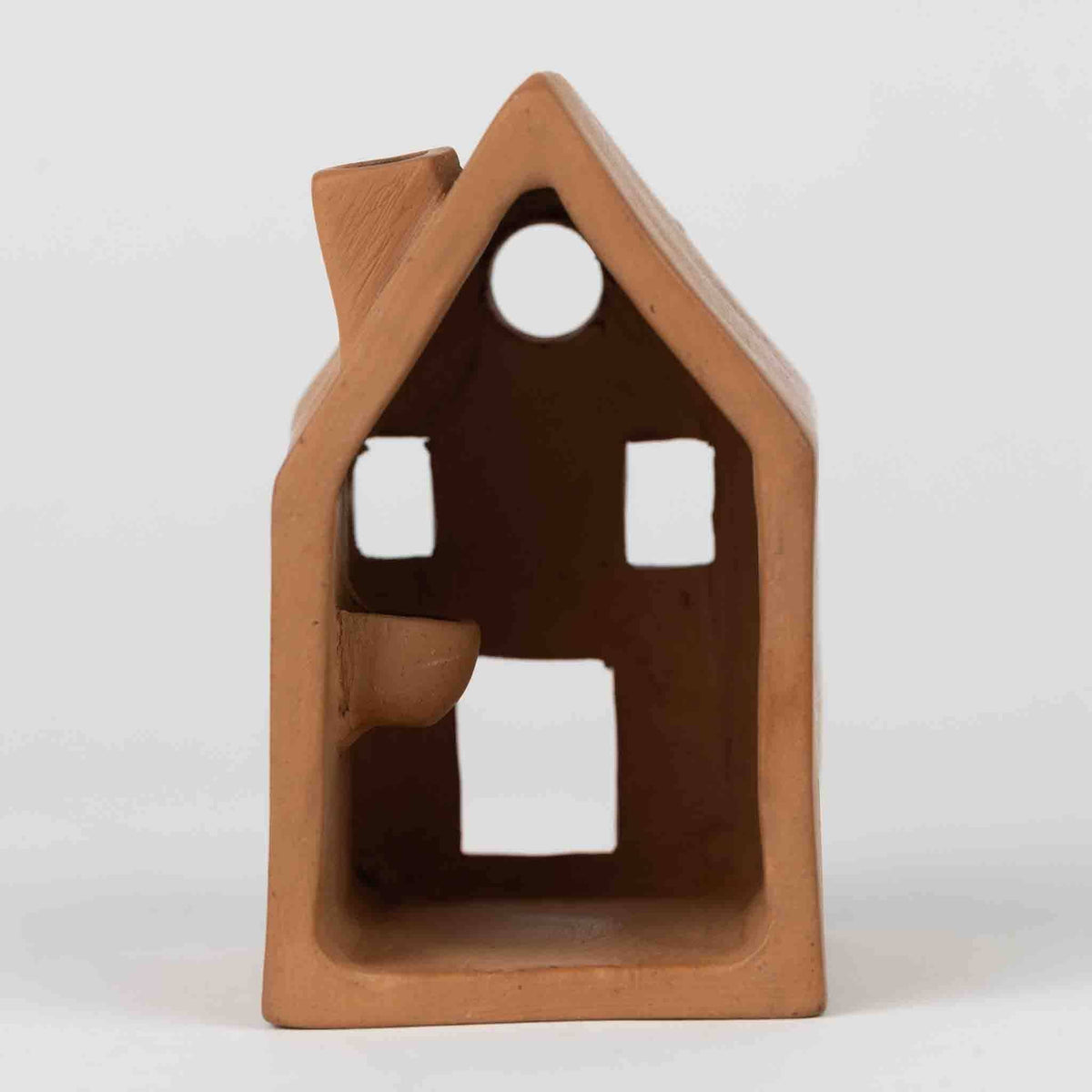 Terra cotta house-shaped object on a white background