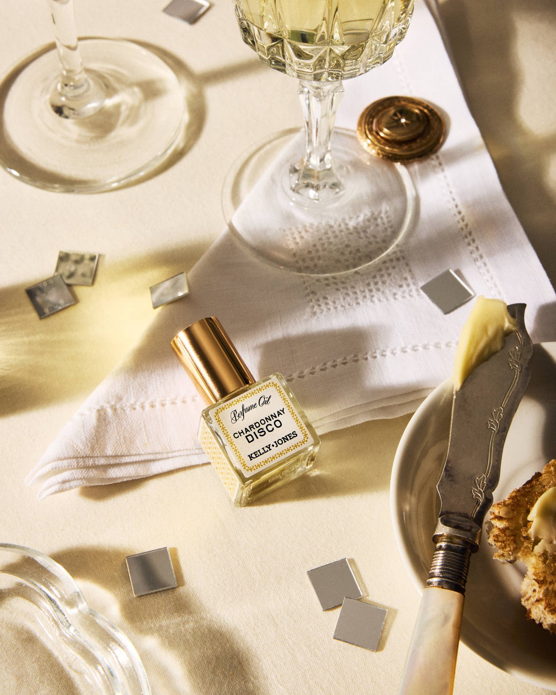 Perfume bottle labeled 'Chanel No. 5' on a table with wine glasses and food.