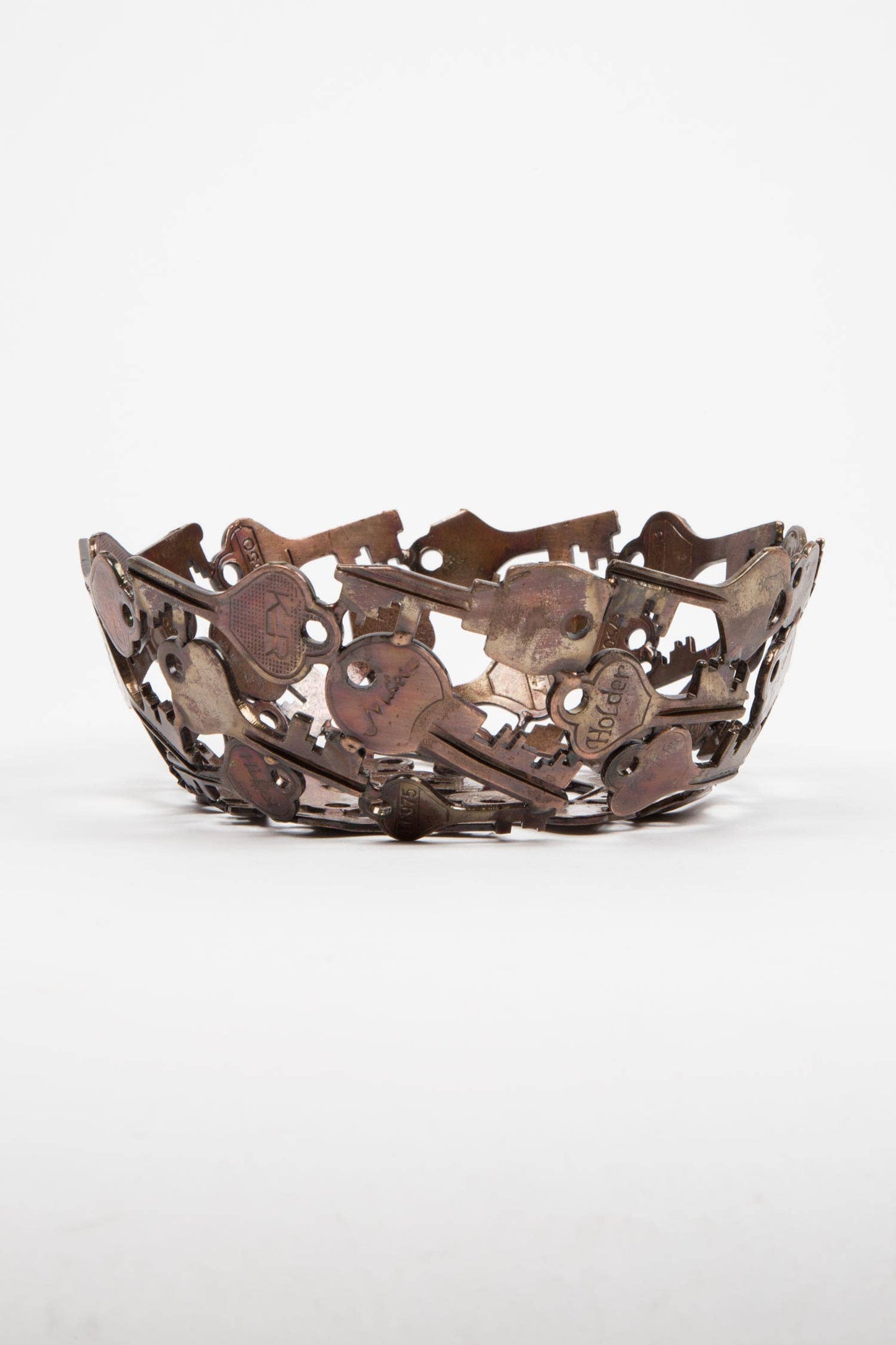 Decorative metal bowl with intricate cut-out designs on a white background