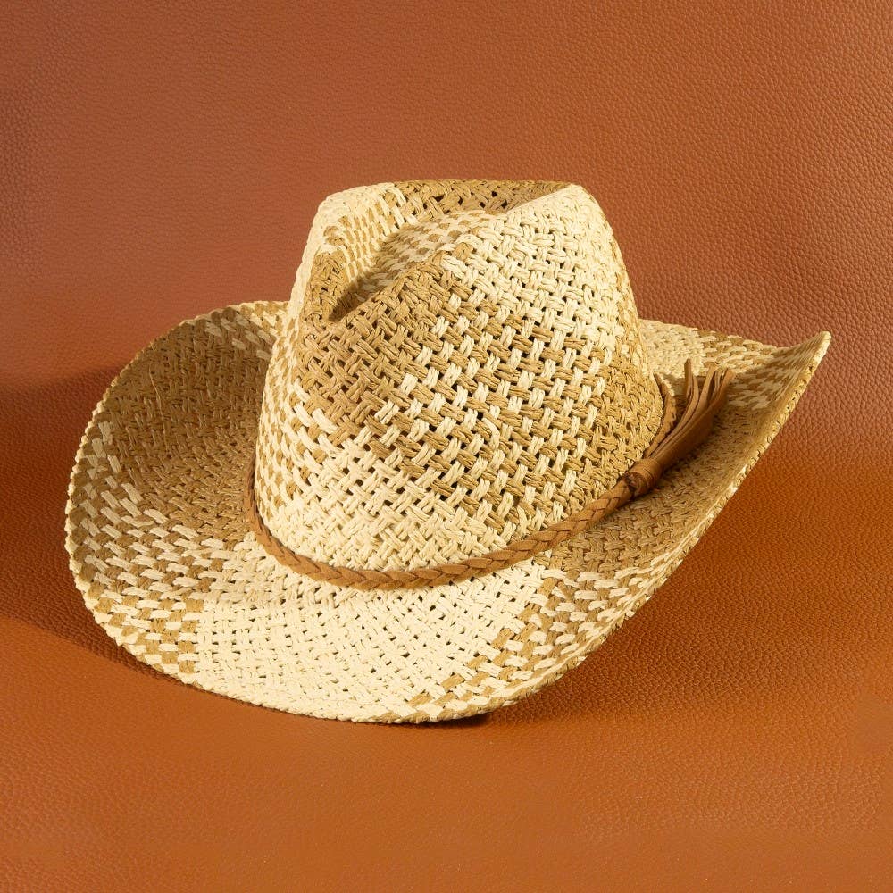 Straw cowboy hat with a feather on an orange background