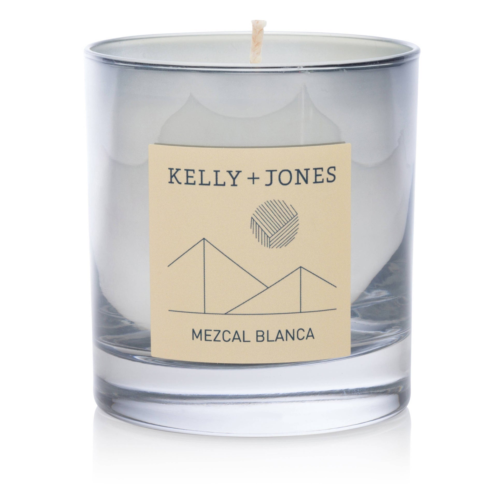Clear glass candle with a beige label featuring 'Kelly + Jones' and 'Mezcal Blanca' on a white background.