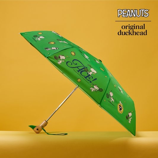 Green umbrella with cartoon characters on a yellow background, featuring the Peanuts brand.