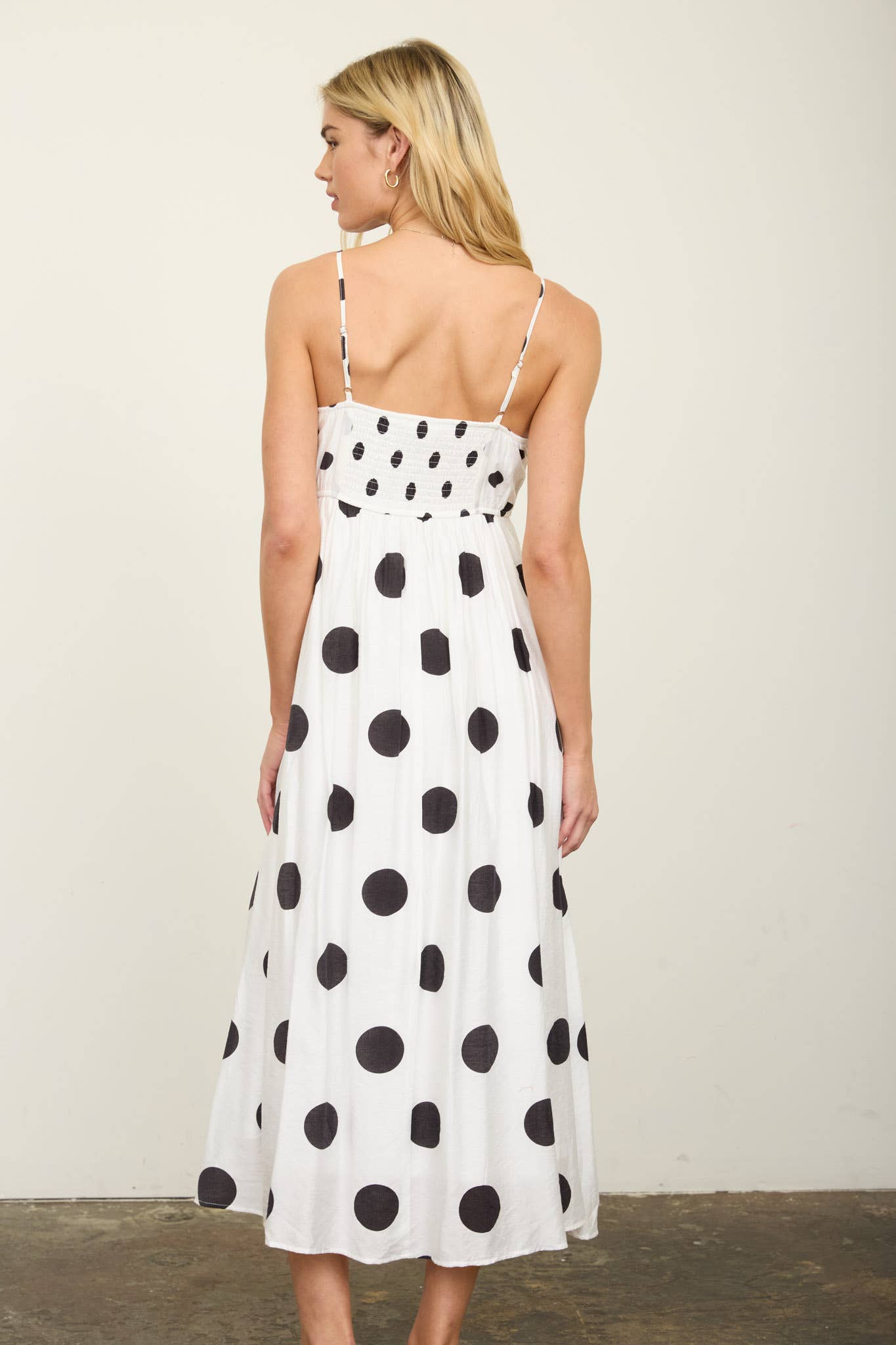 Woman wearing a polka dot dress against a plain background
