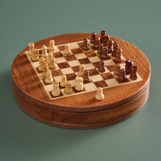 Wooden chessboard with pieces on a green background
