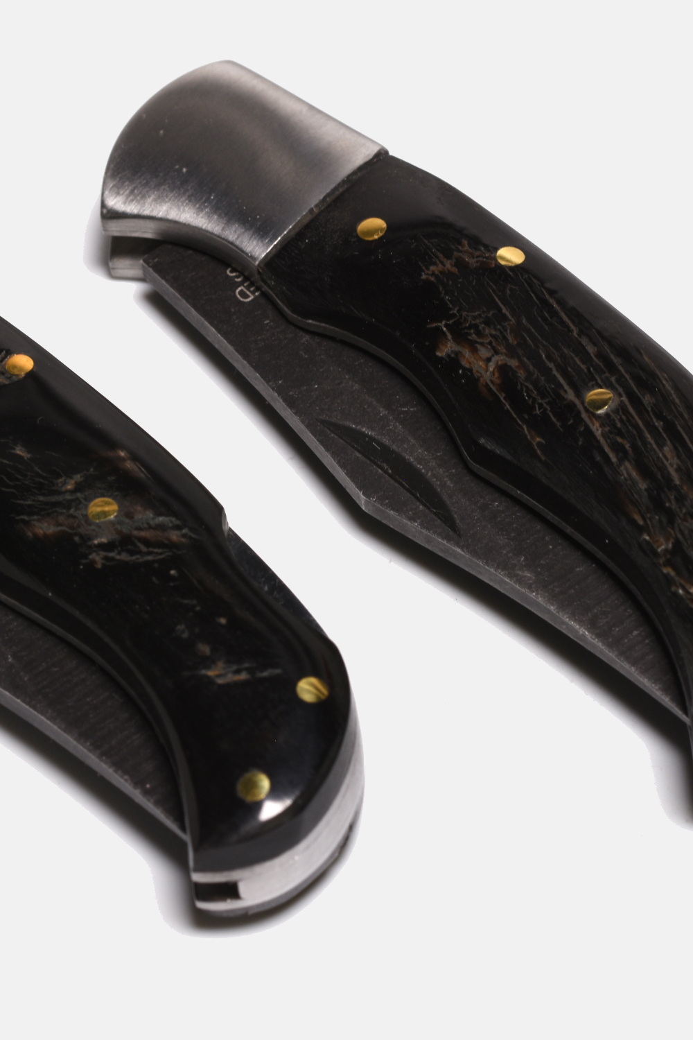 Two folding knives with black handles and metallic blades on a white background