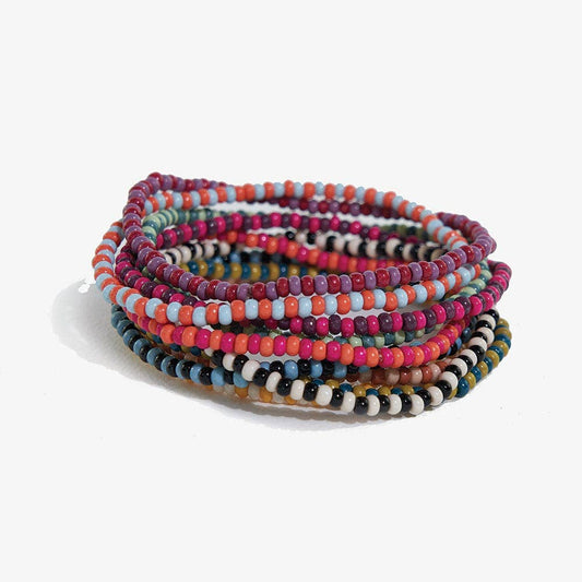 Stack of colorful beaded bracelets on a white background