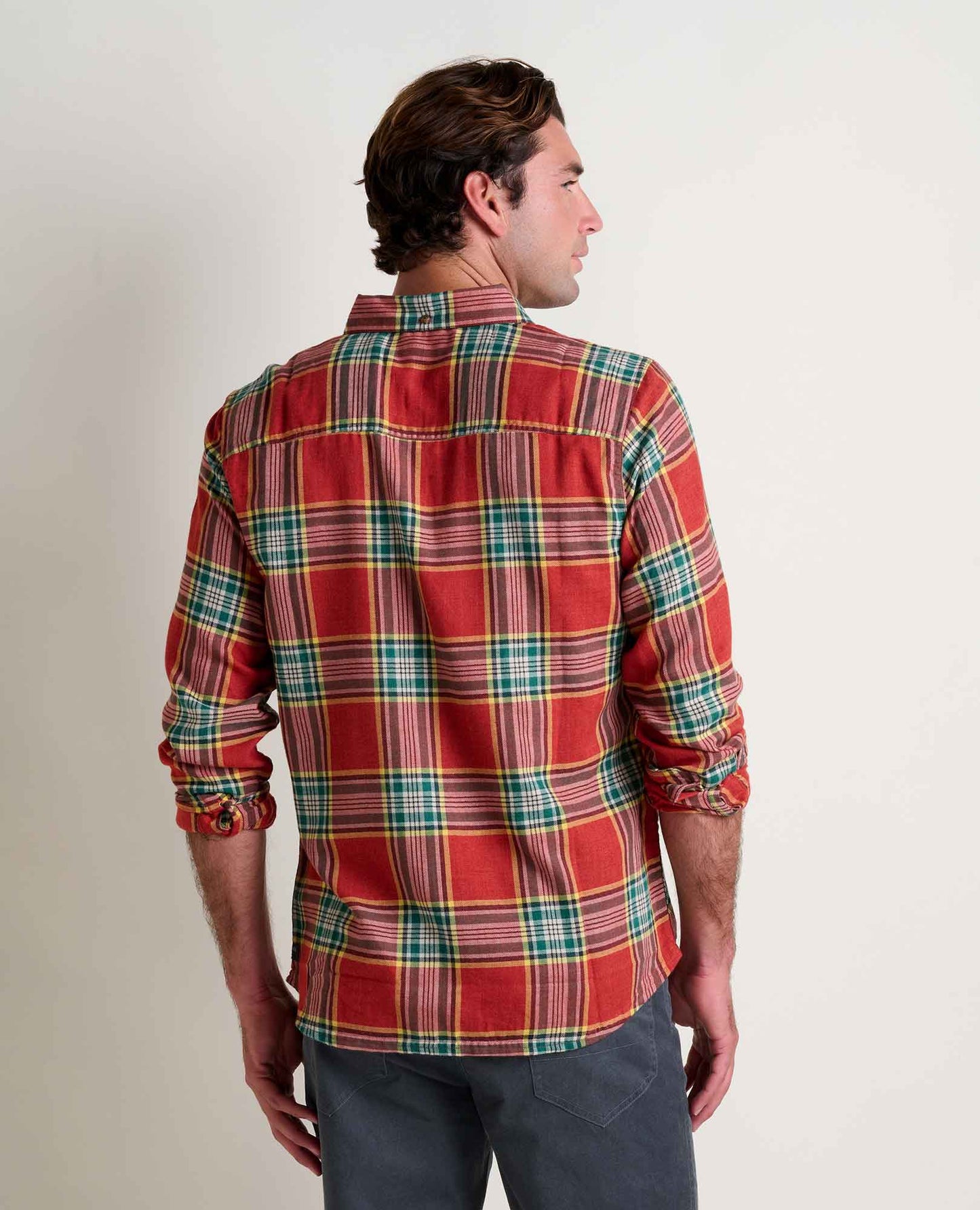 Man wearing a red plaid shirt against a plain background