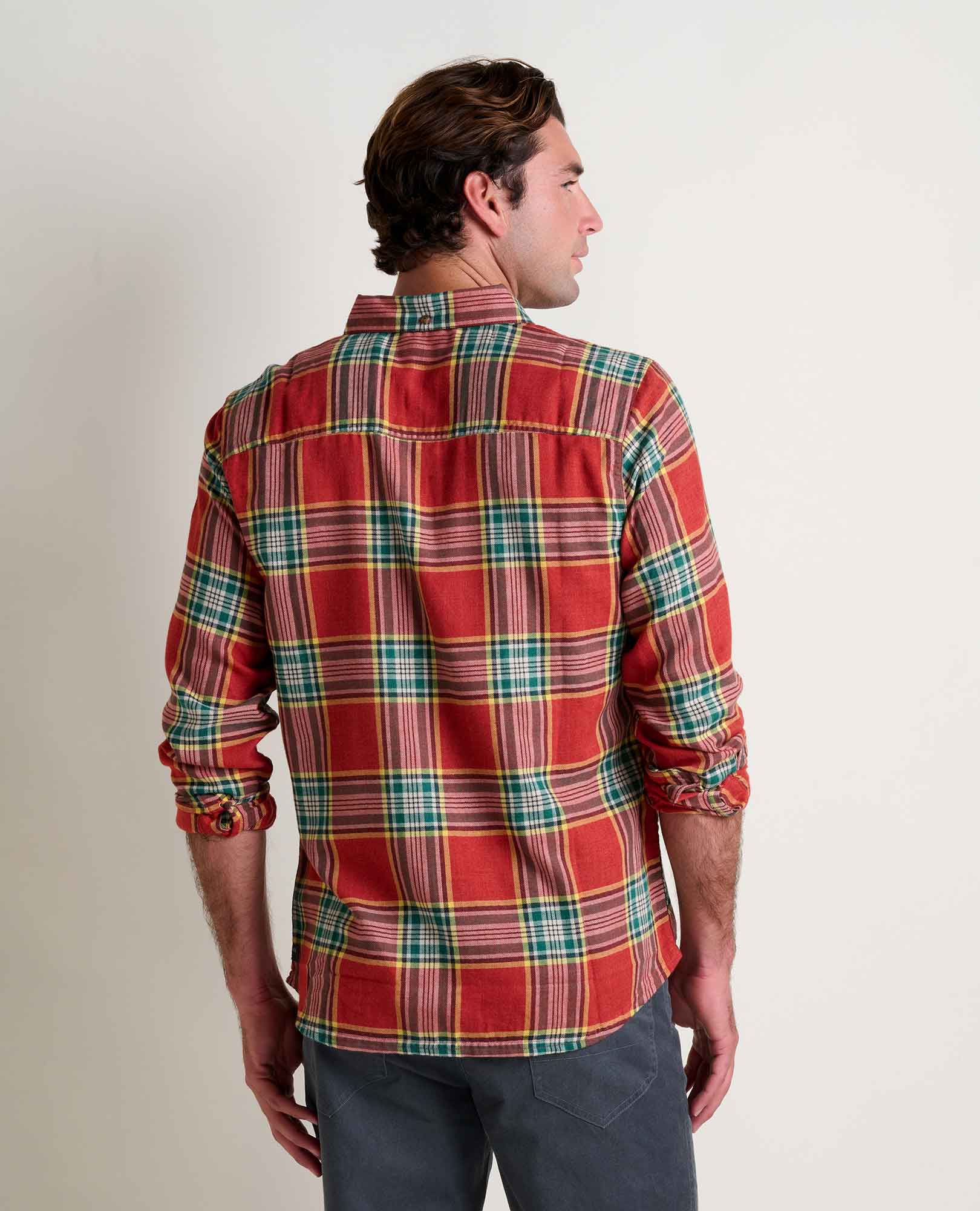 Man wearing a red plaid shirt against a plain background