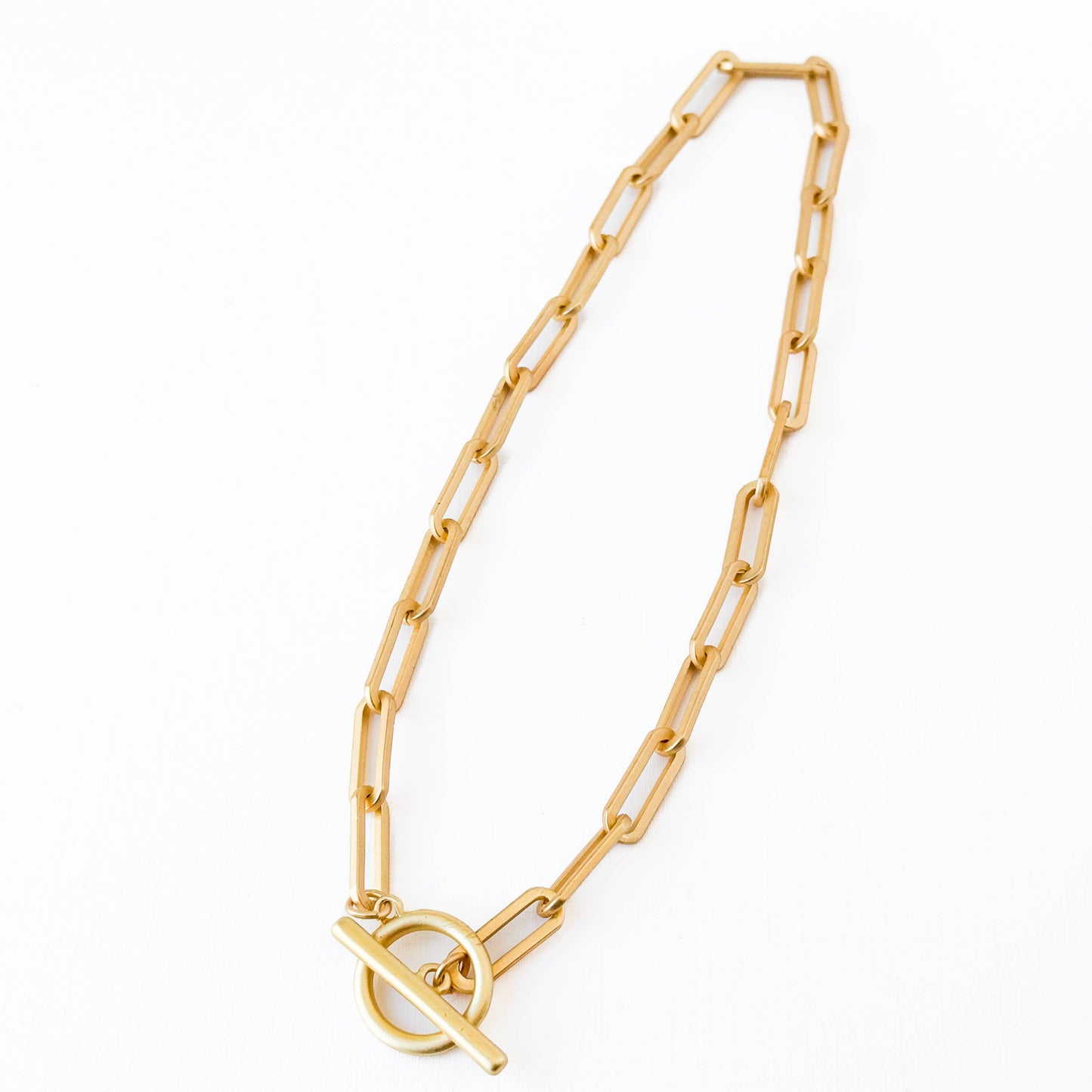 Gold chain necklace with a pendant on a white background