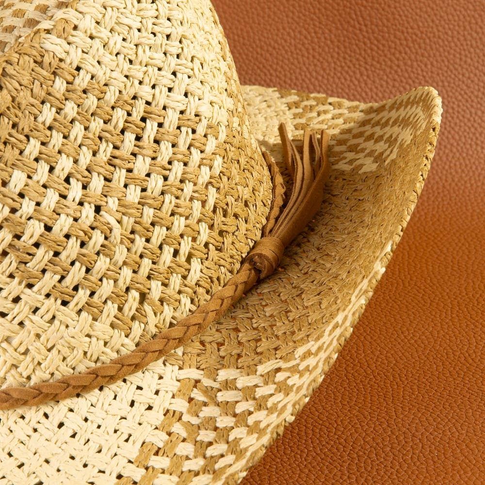 Close-up of a straw hat with a brown band on a brown background