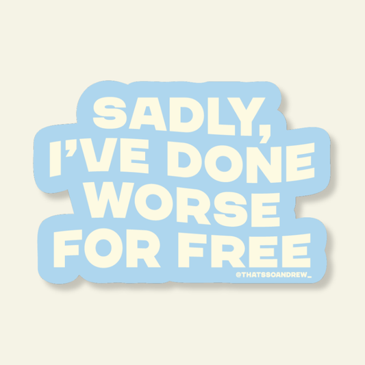 A die-cut sticker with the text 'SADLY, I'VE DONE WORSE FOR FREE' in cream lettering on a light blue background, shown on a warm off-white backdrop.