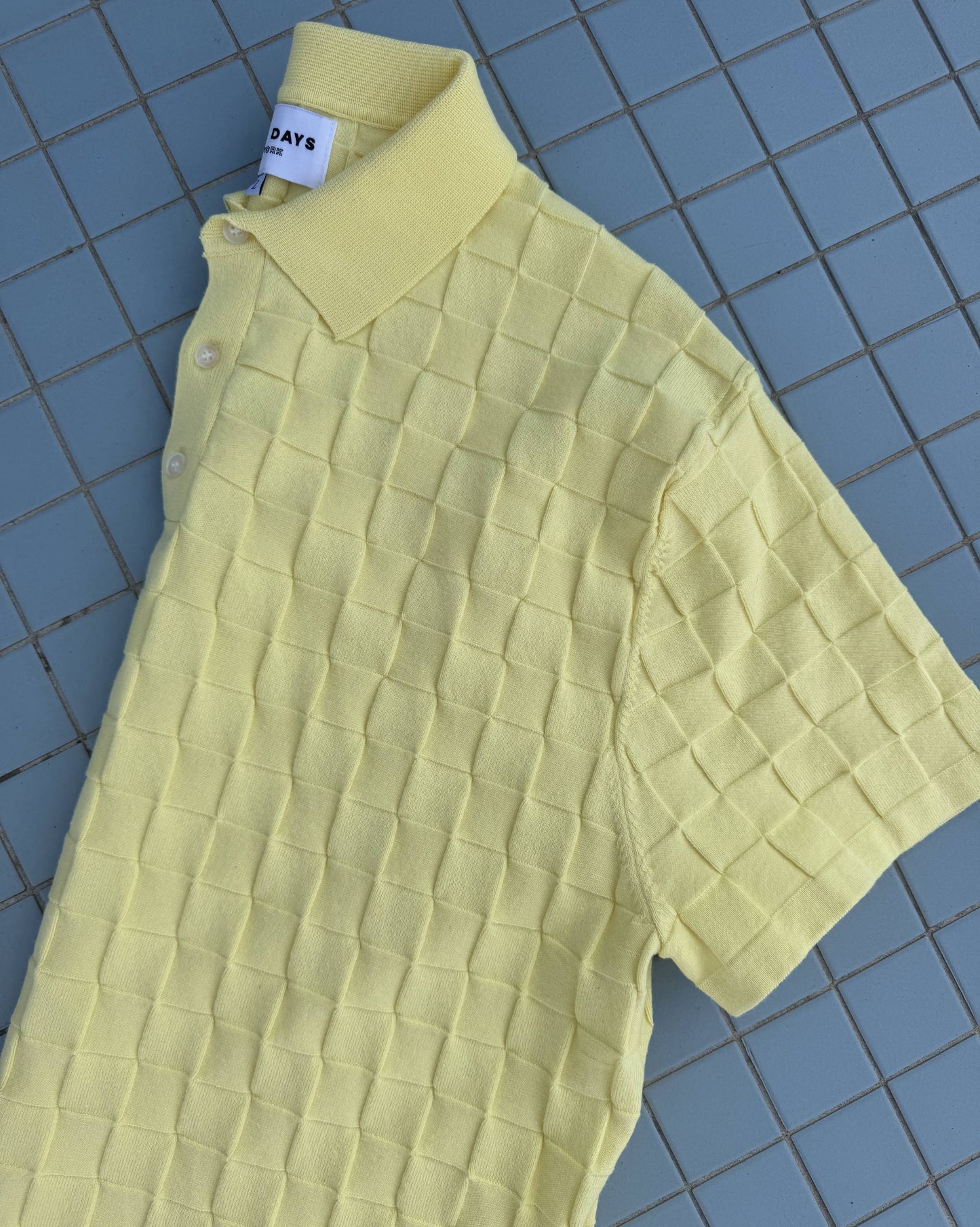Yellow textured dress on a blue tiled floor