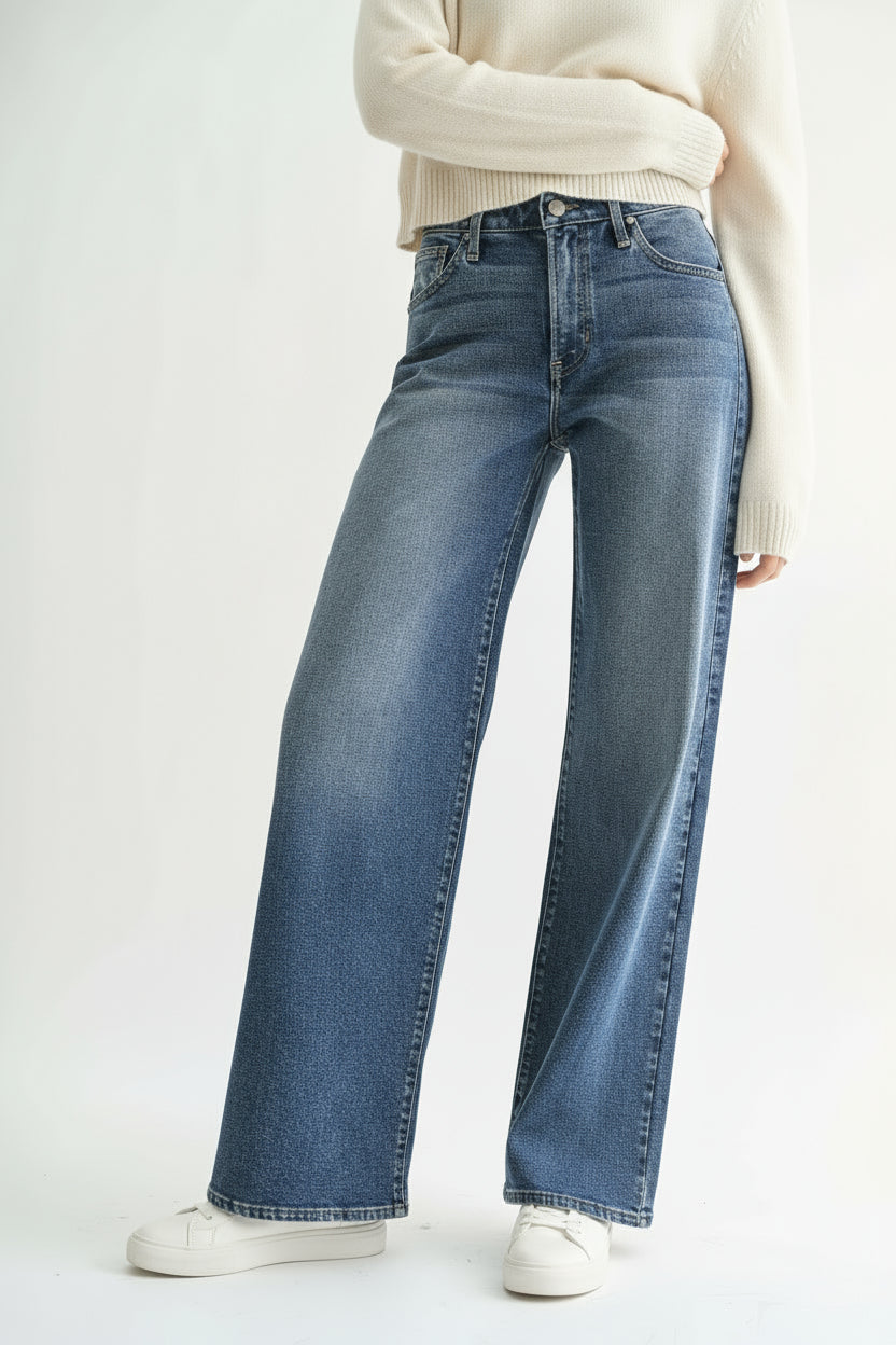 Person wearing blue wide-leg jeans on a white background
