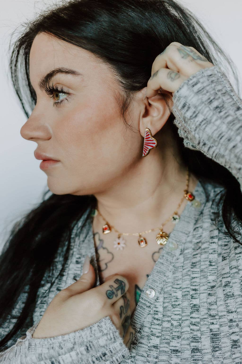 Woman wearing earrings and a necklace with a neutral background