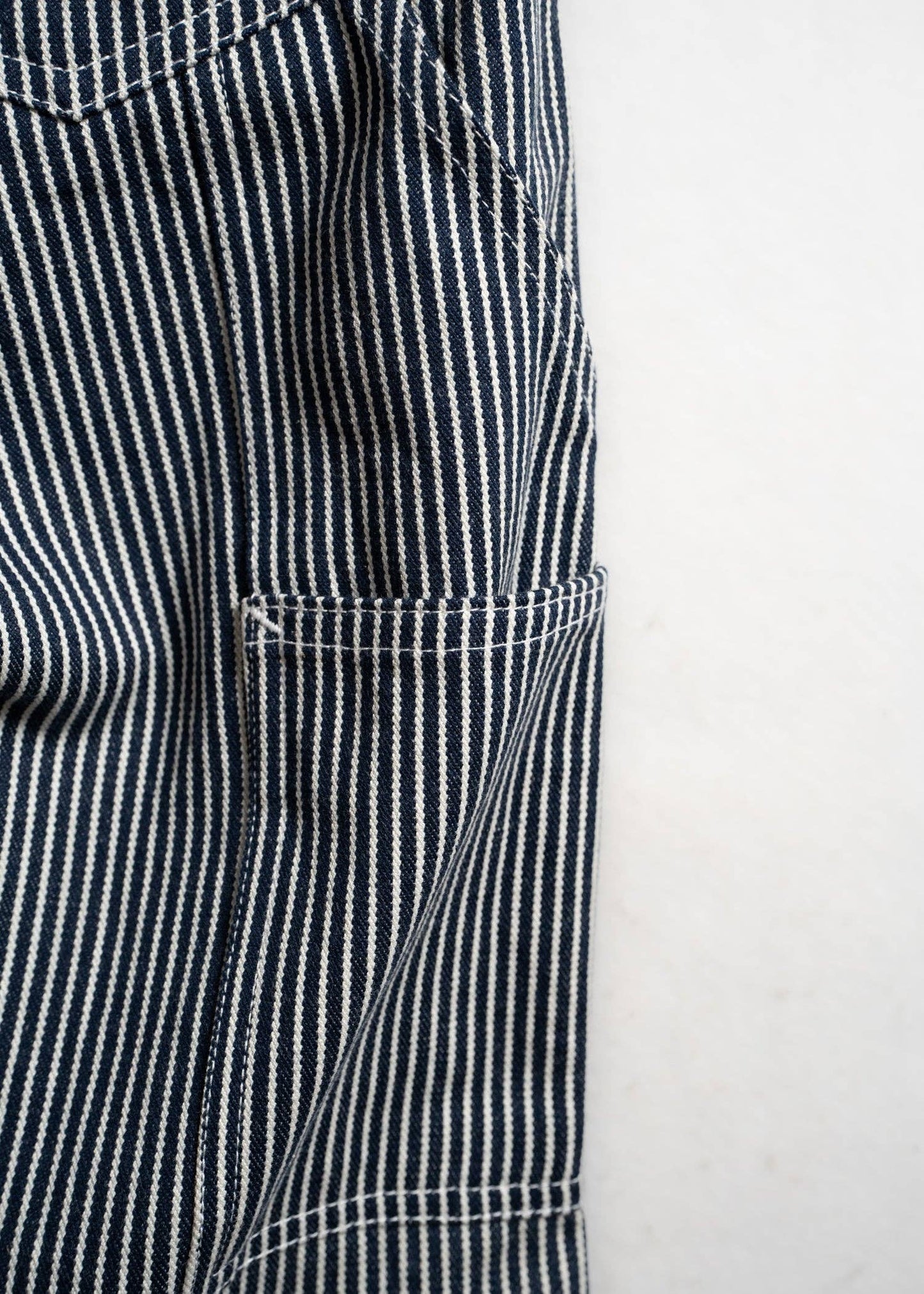 Close-up of a black and white striped fabric with a pocket on a light gray background