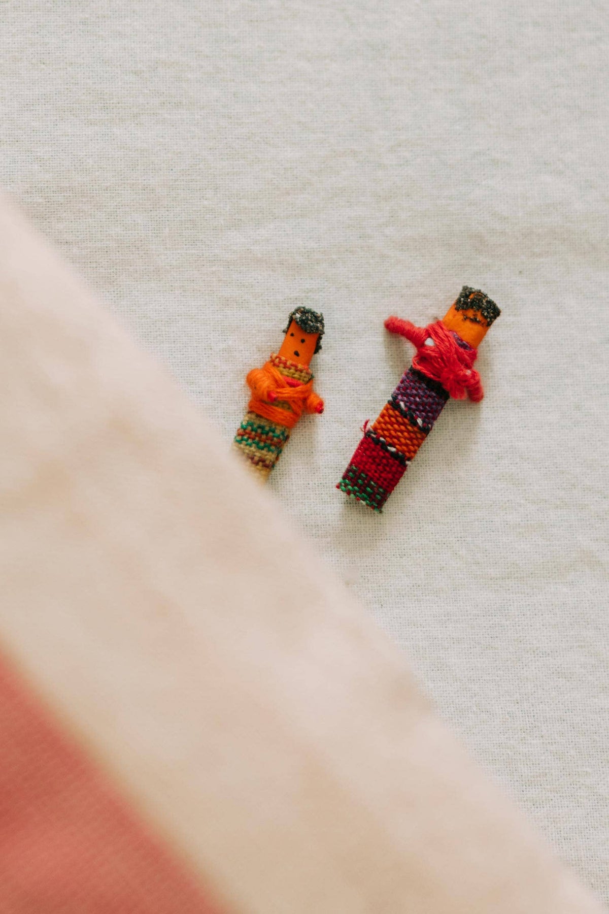 Two colorful figurines on a textured surface