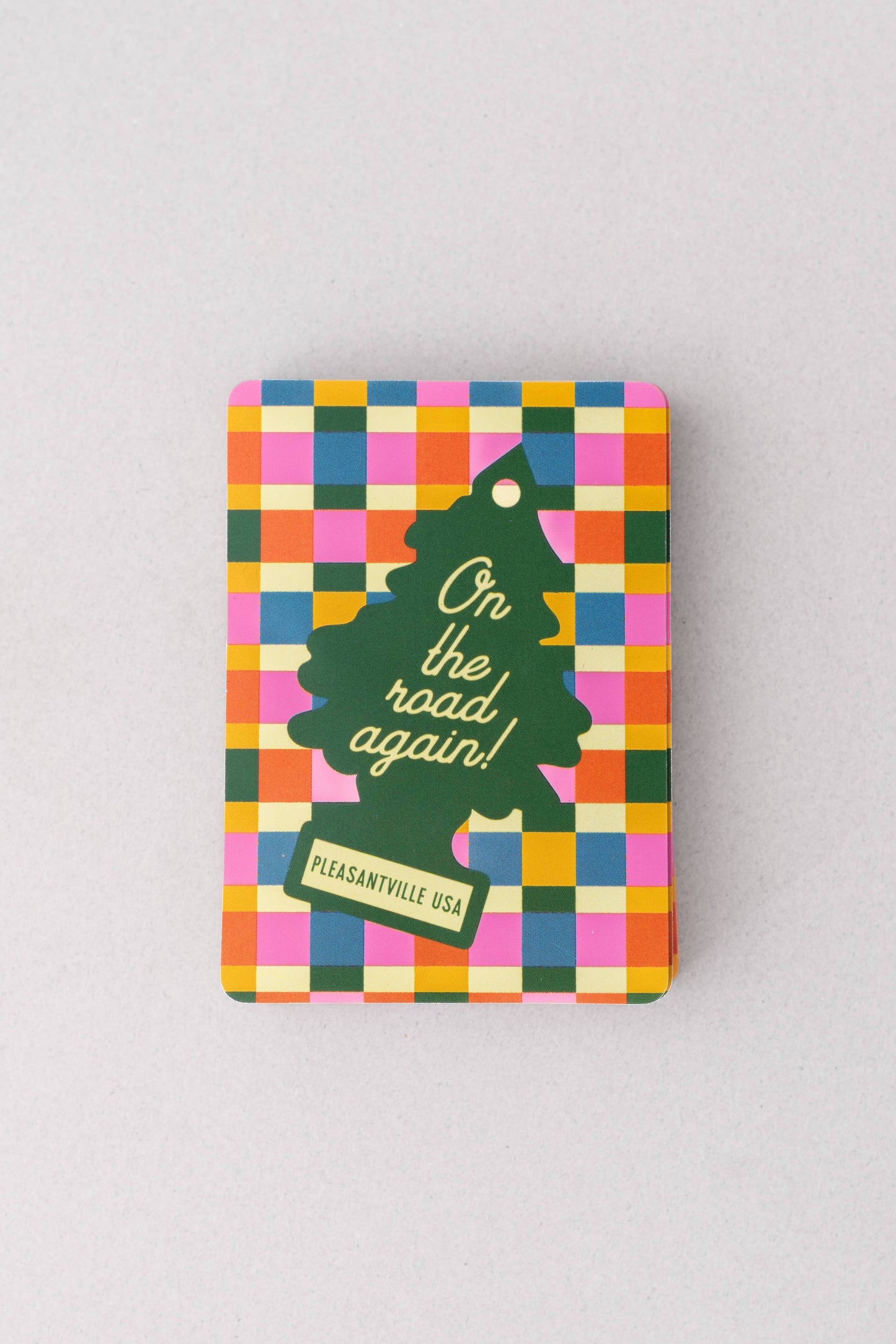 Colorful checkered notebook with a green tree illustration and text on a gray background