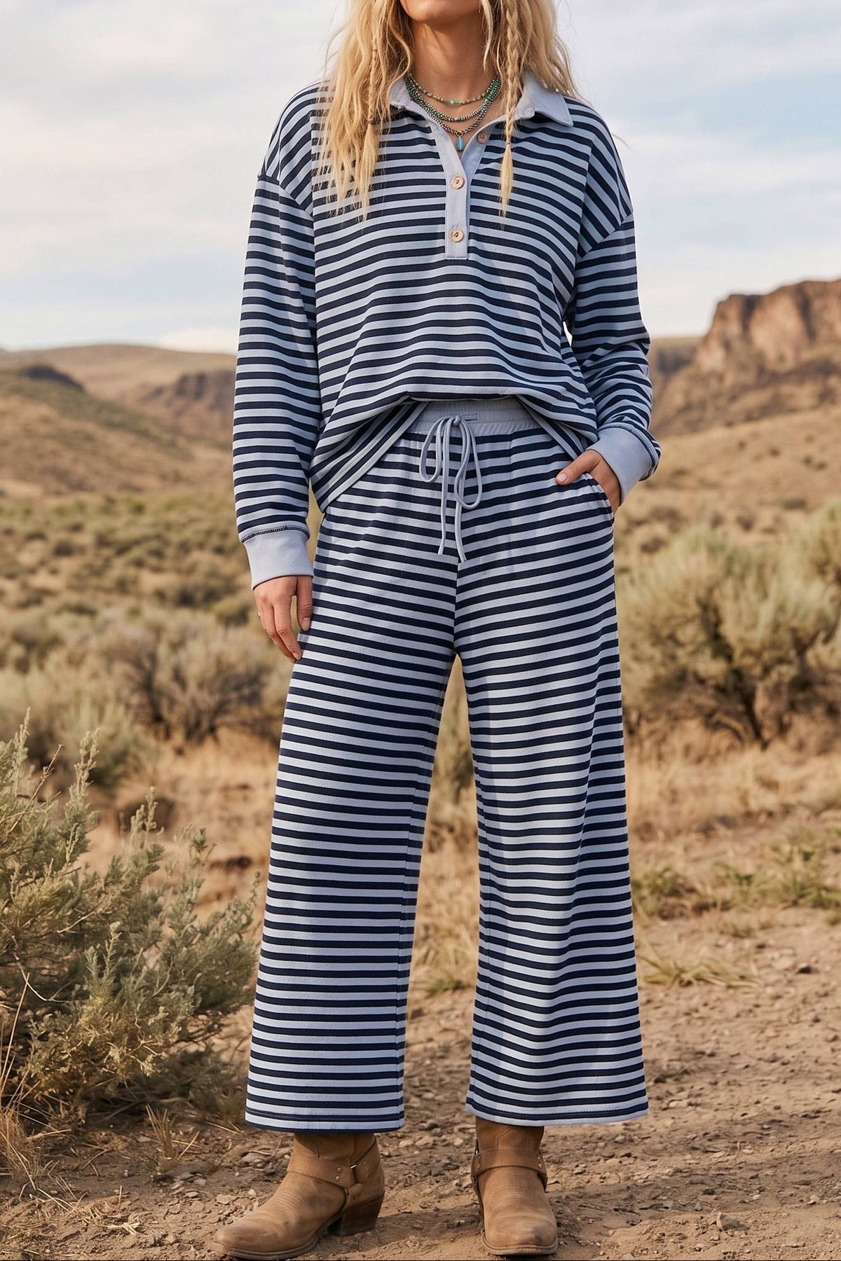 Woman wearing a blue and white striped outfit standing in a desert landscape.