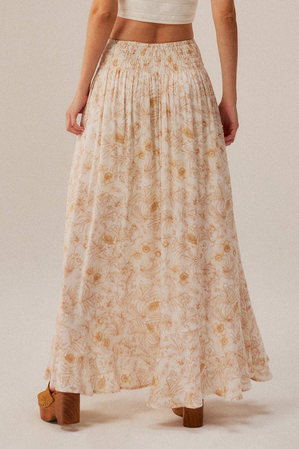 Person wearing a floral skirt with a plain background